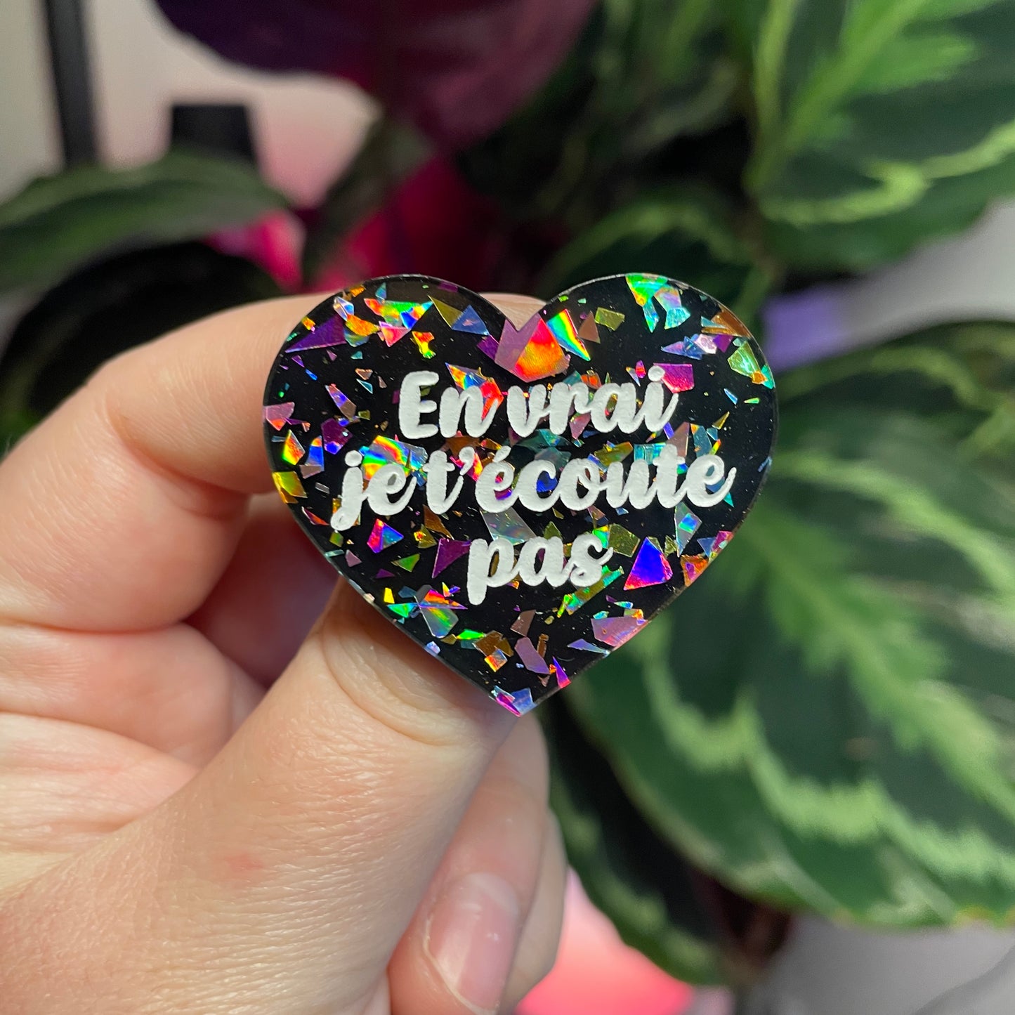 Broche "En vrai je t'écoute pas" en acrylique noire avec des éclats de confettis multicolores