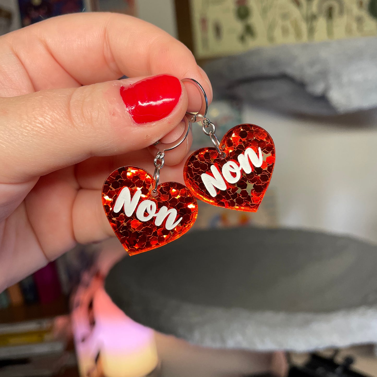 Petites boucles d'oreilles coeurs pendantes "Non" en acrylique semi transparente avec des confettis rouges