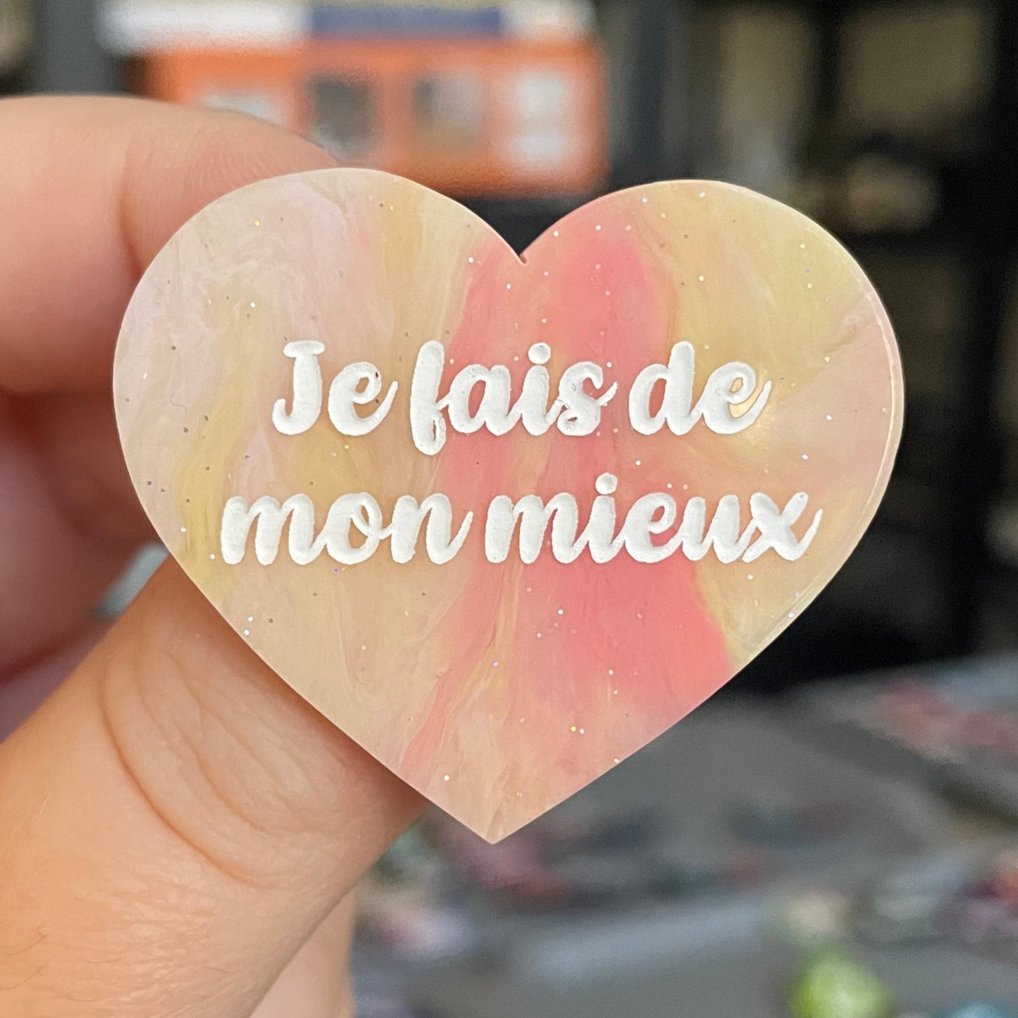 Broche "Je fais de mon mieux" en acrylique marbrée semi-transparente orange, corail, blanche et jaune à paillettes