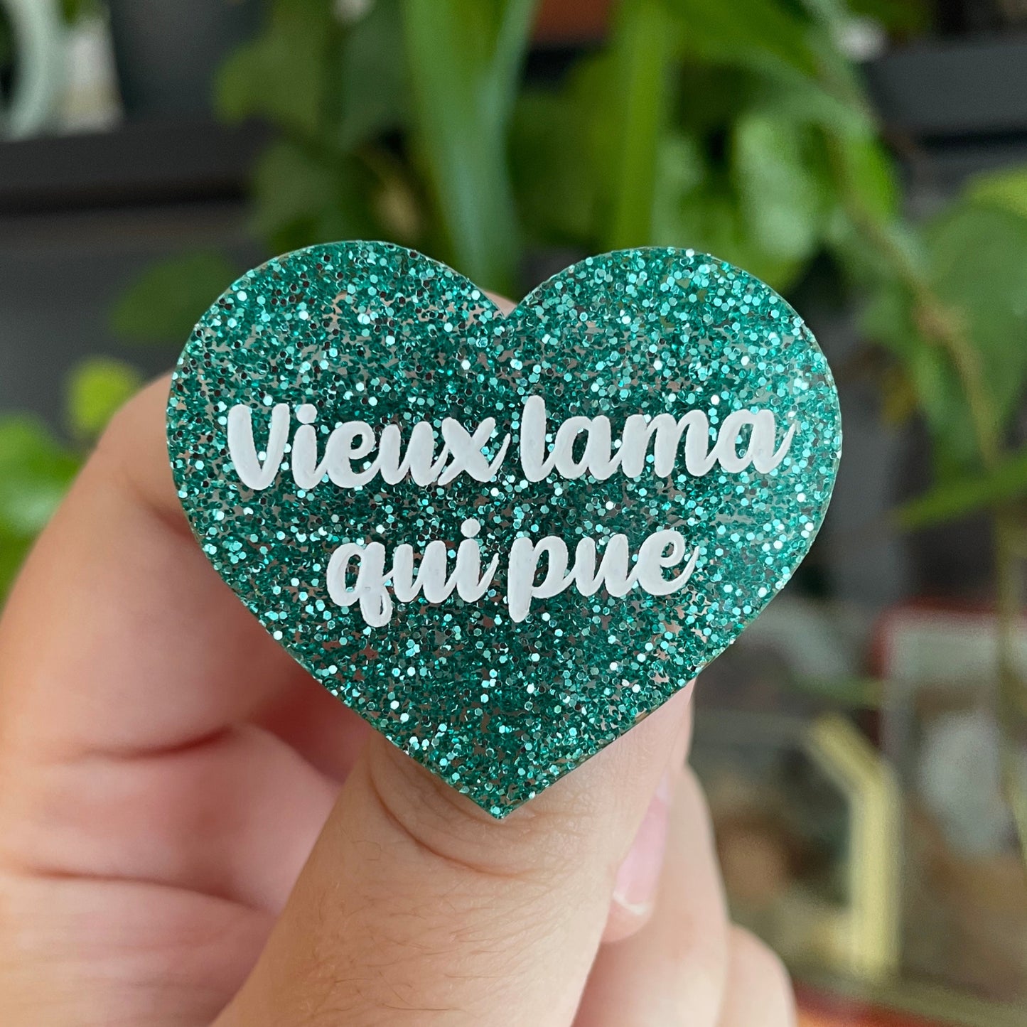 Broche "Vieux lama qui pue" en acrylique à paillettes turquoise