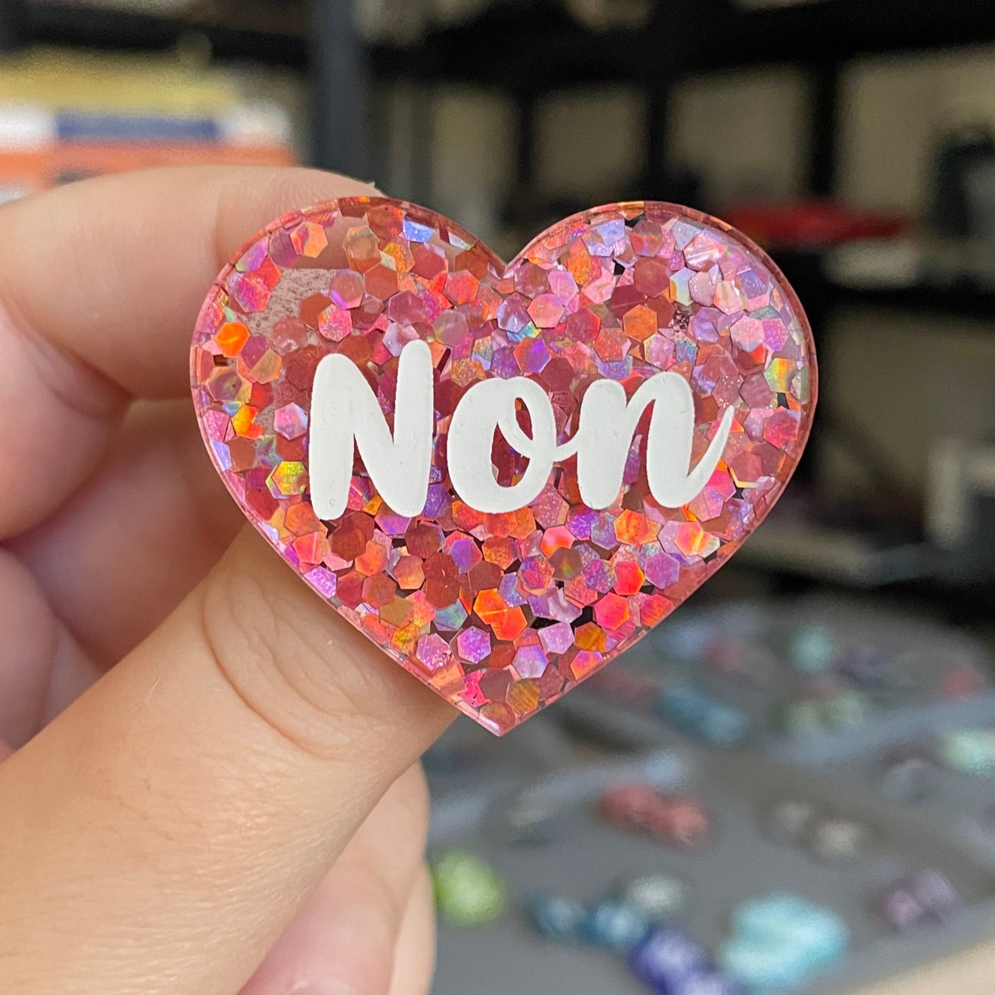 Broche "Non" en acrylique semi-transparente avec des confettis corail