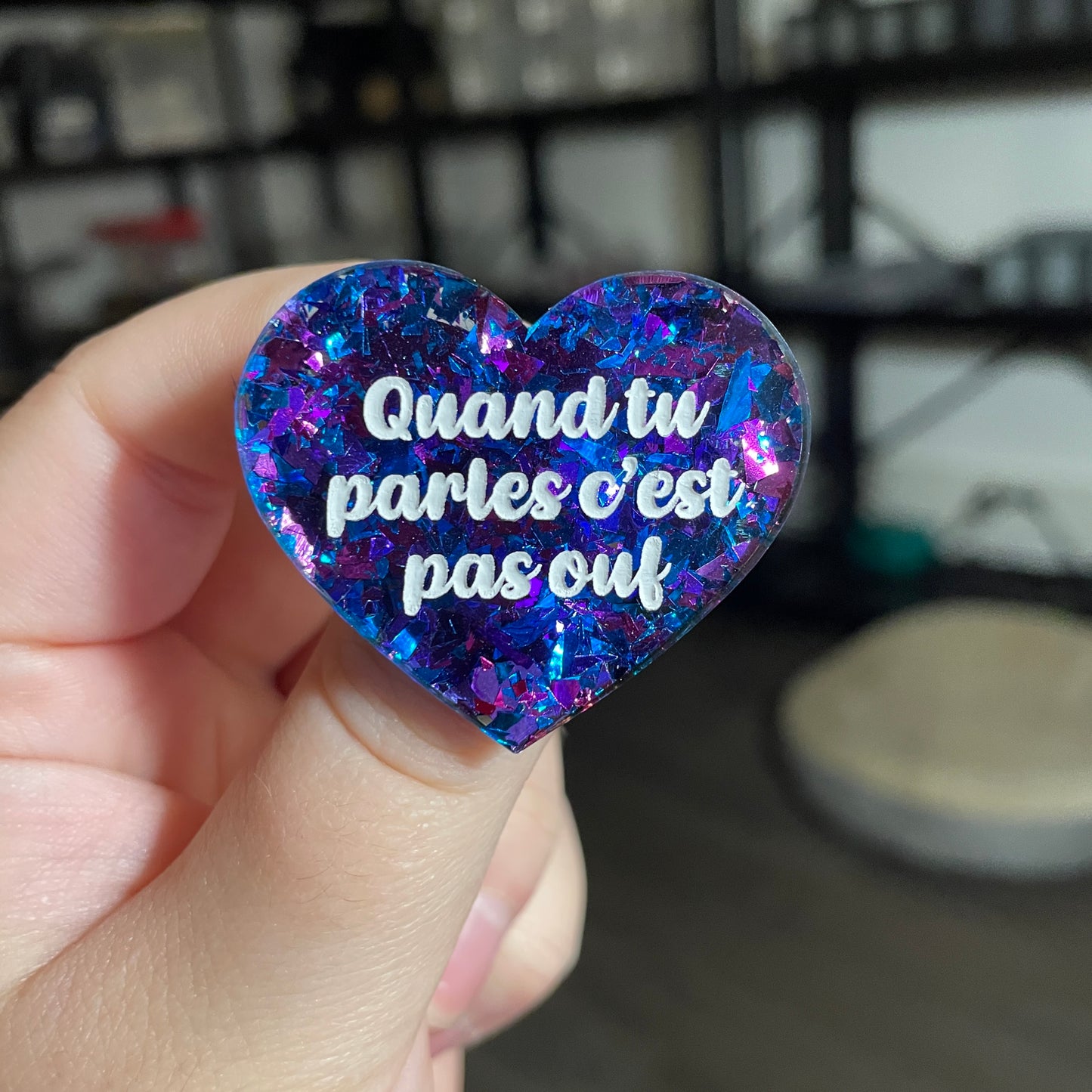 Broche "Quand tu parles c'est pas ouf" en acrylique transparente avec des éclats de confettis bleus et violets