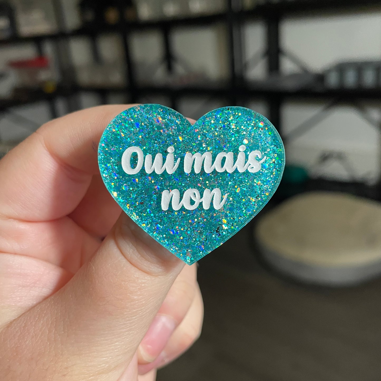Broche "Oui mais non" en acrylique à paillettes turquoise
