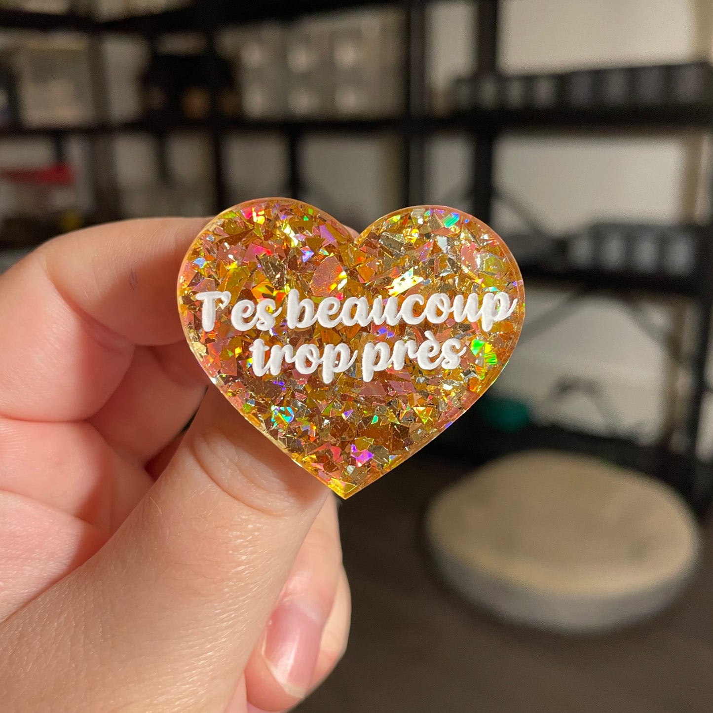 Broche "T'es beaucoup trop près" en acrylique transparente avec des confettis jaunes