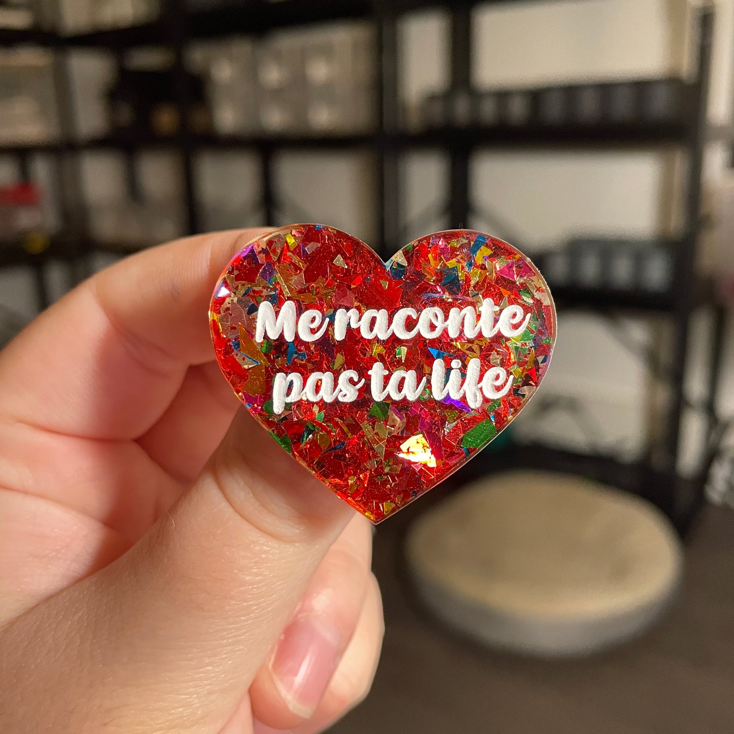 Broche "Me raconte pas ta life" en acrylique transparente avec des confettis rouges et multicolores