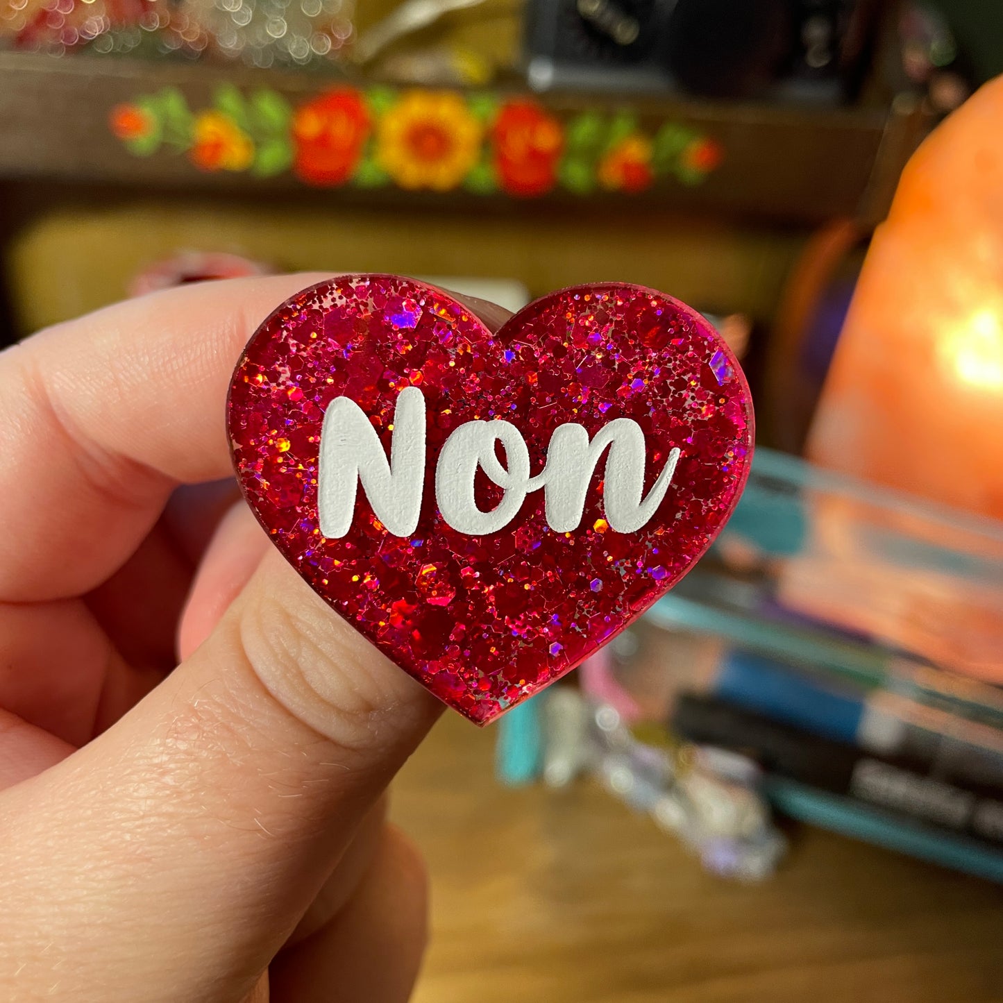 Broche "Non" en acrylique semi transparente à paillettes rouges