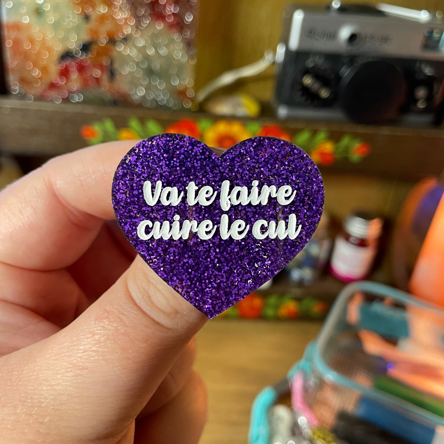 Broche "Va te faire cuire le cul" en acrylique à paillettes violettes