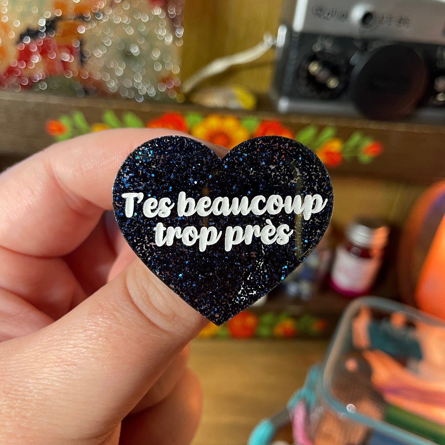 Broche "T'es beaucoup trop près" en acrylique à paillettes bleues foncées