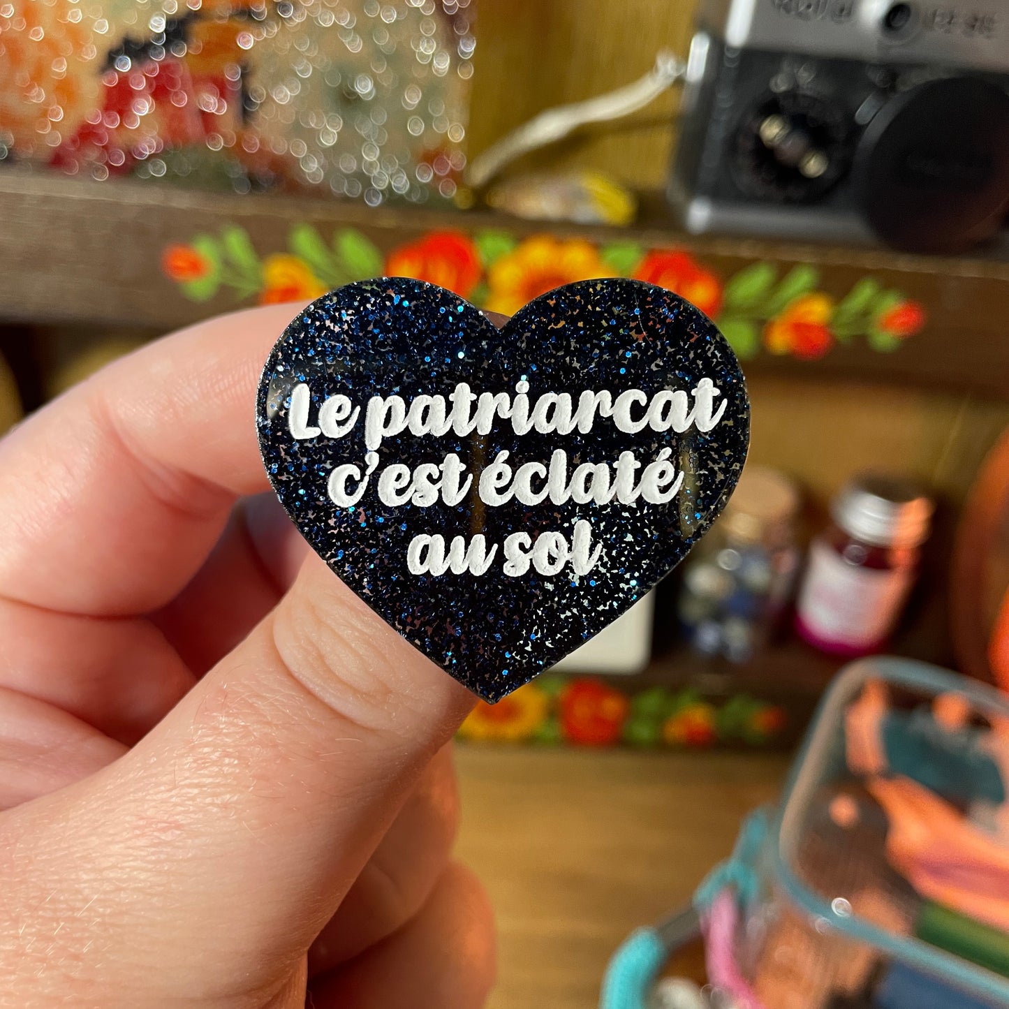 Broche "Le patriarcat c'est éclaté au sol" en acrylique à paillettes bleues foncées