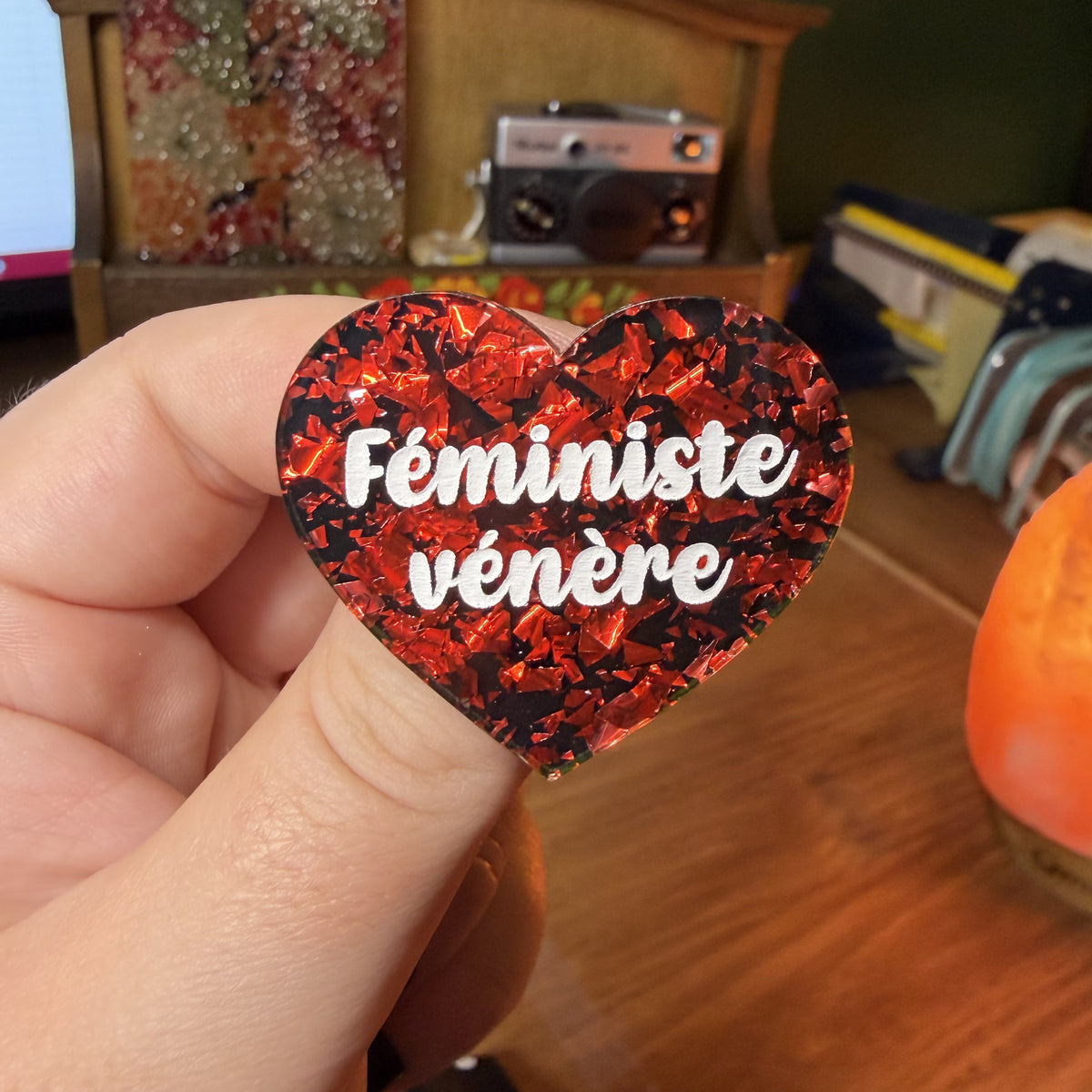 Broche "Féministe vénère" en acrylique noire avec des éclats de confettis rouges