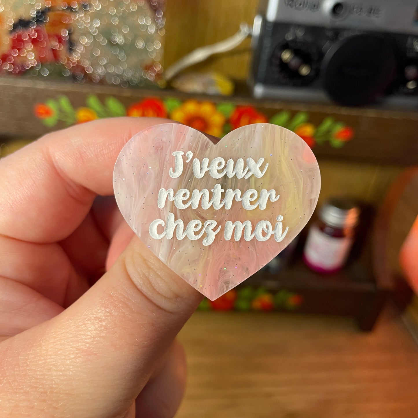 Broche "J'veux rentrer chez moi" en acrylique semi transparente marbrée corail, jaune et blanche à paillettes