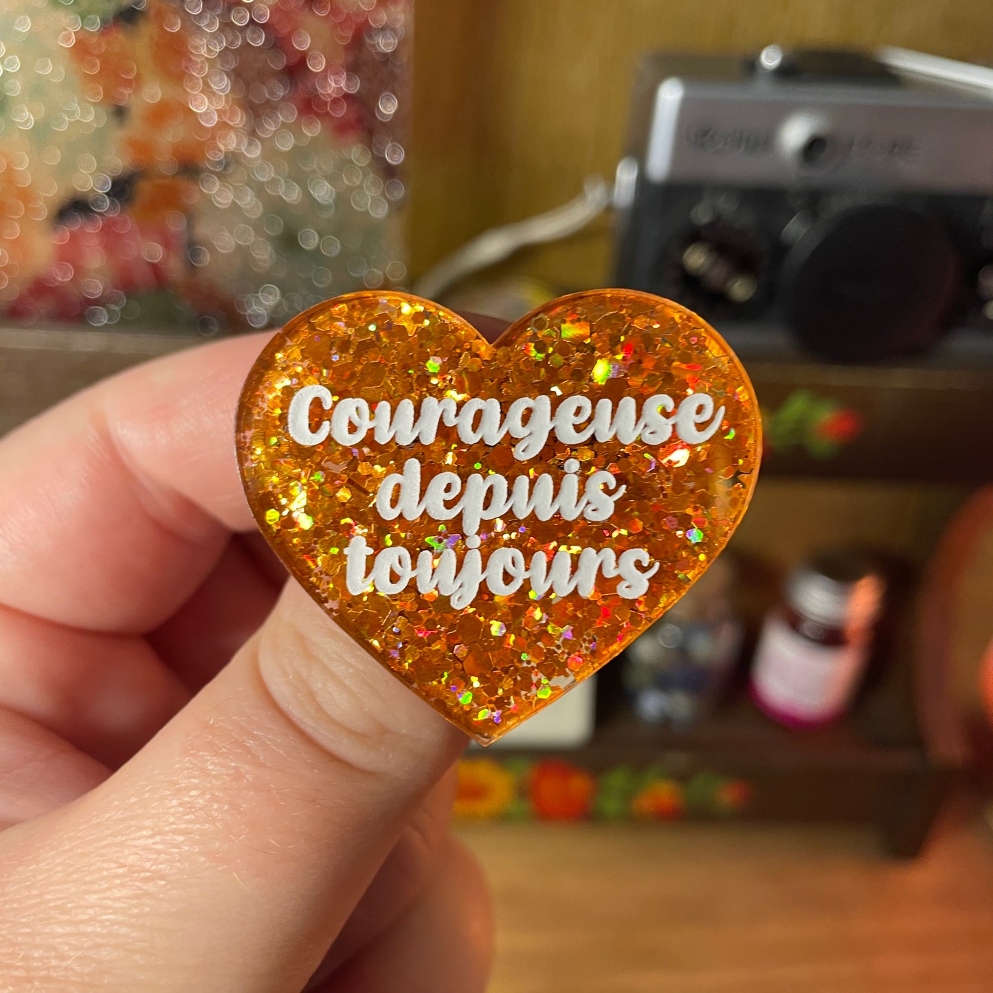 Broche "Courageuse depuis toujours" en acrylique semi transparente à paillettes oranges