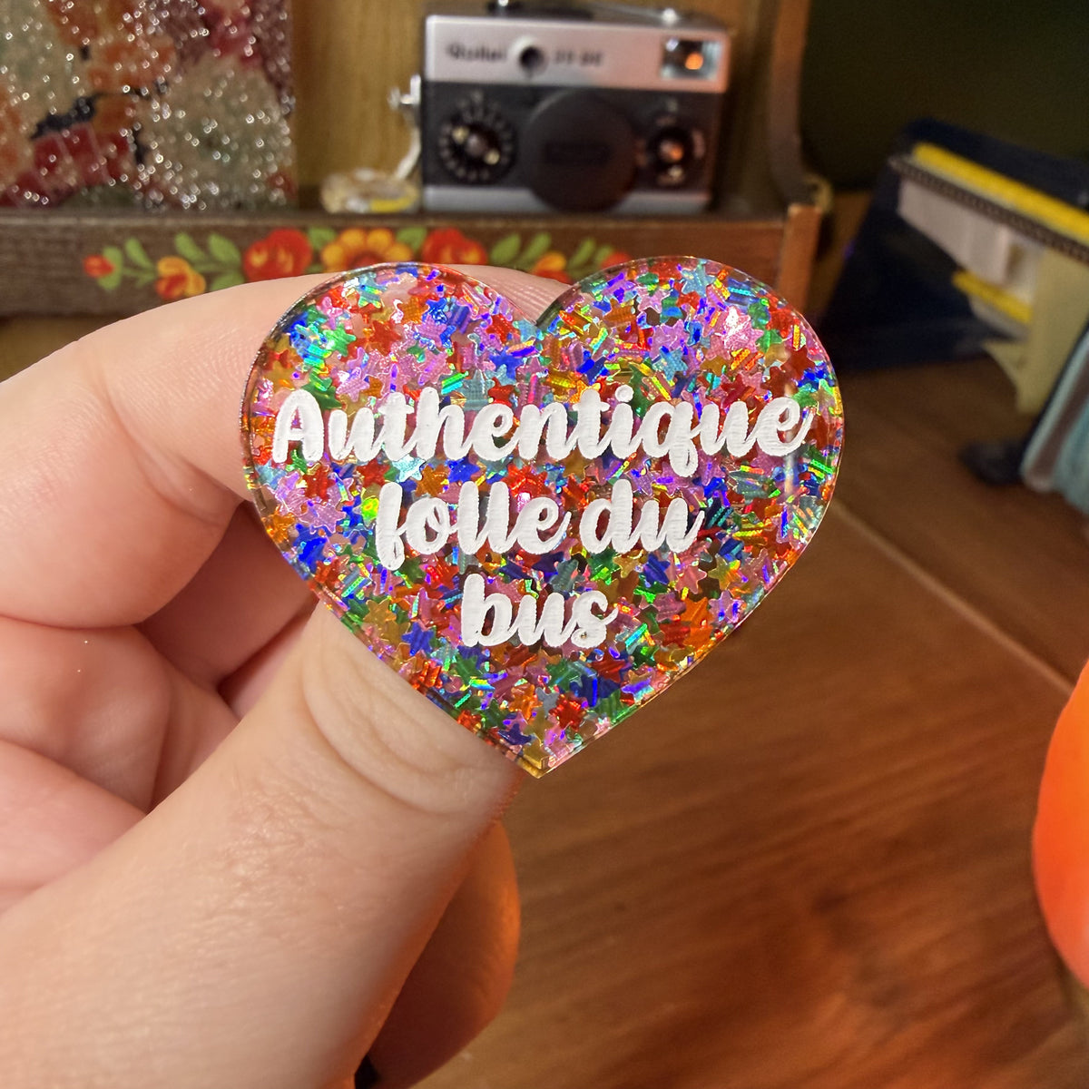 Broche "Authentique folle du bus" en acrylique semi transparente avec des étoiles multicolores