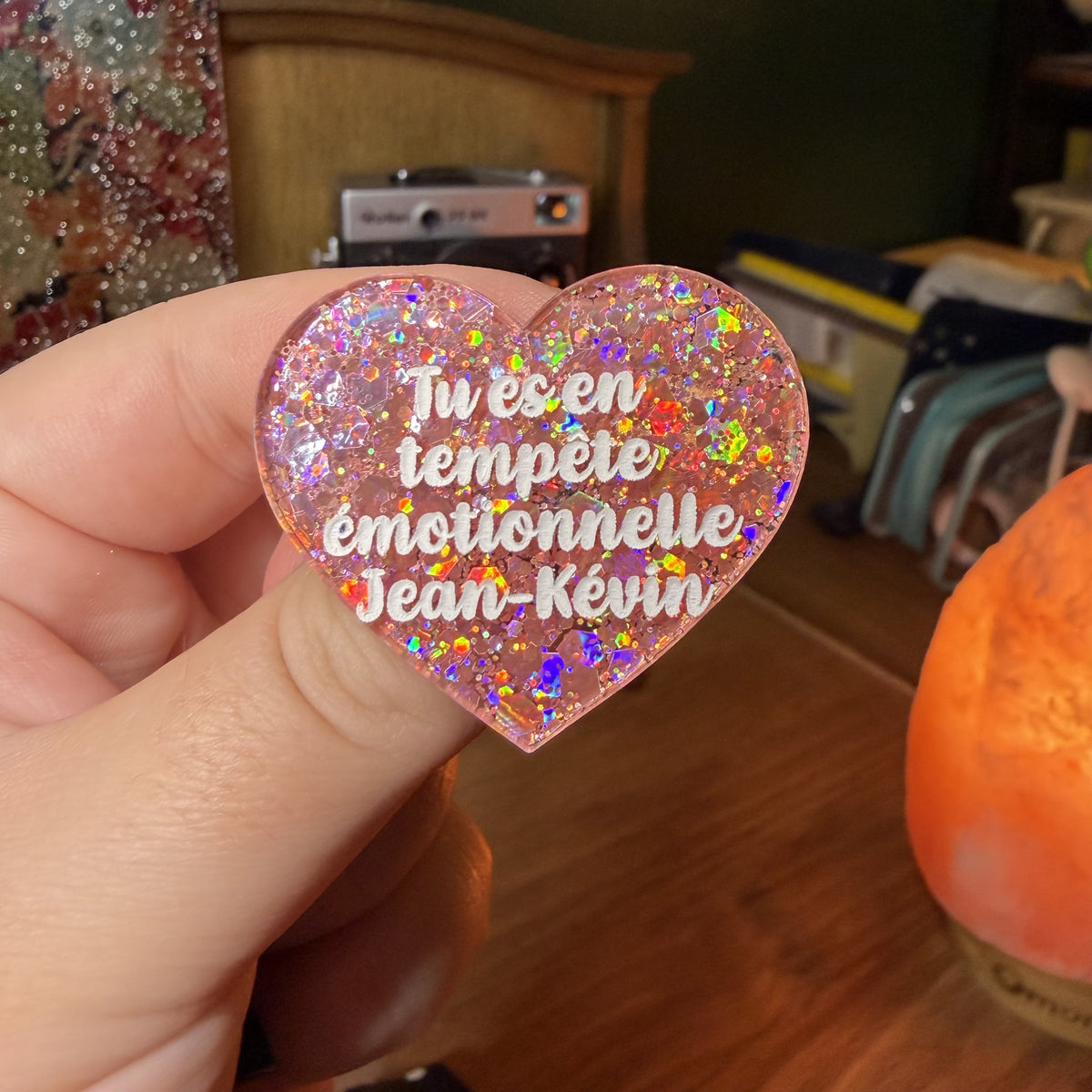 Broche "Tu es en tempête émotionnelle Jean-Kévin" en acrylique semi transparente avec des paillettes corail