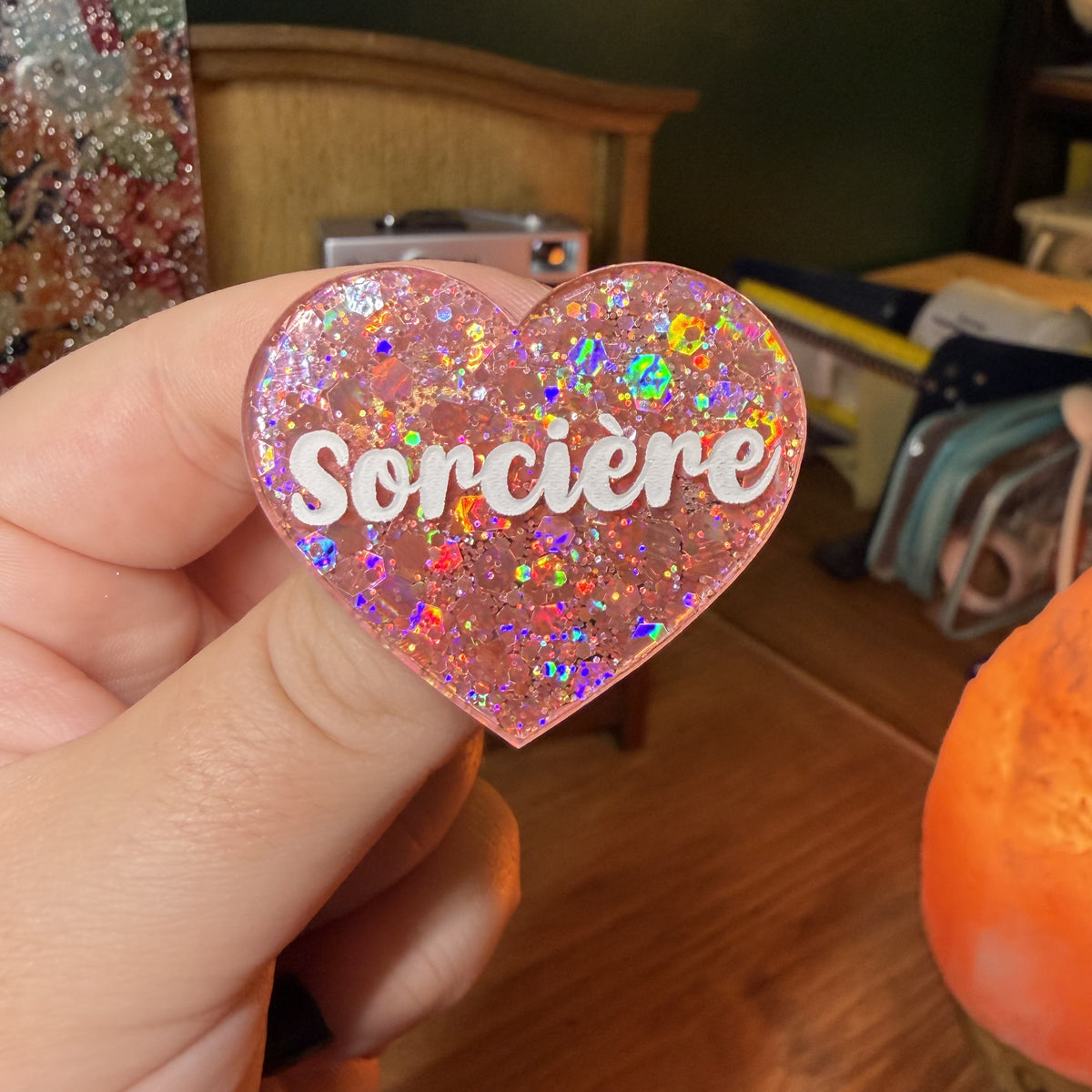 Broche "Sorcière" en acrylique semi transparente avec des paillettes corail