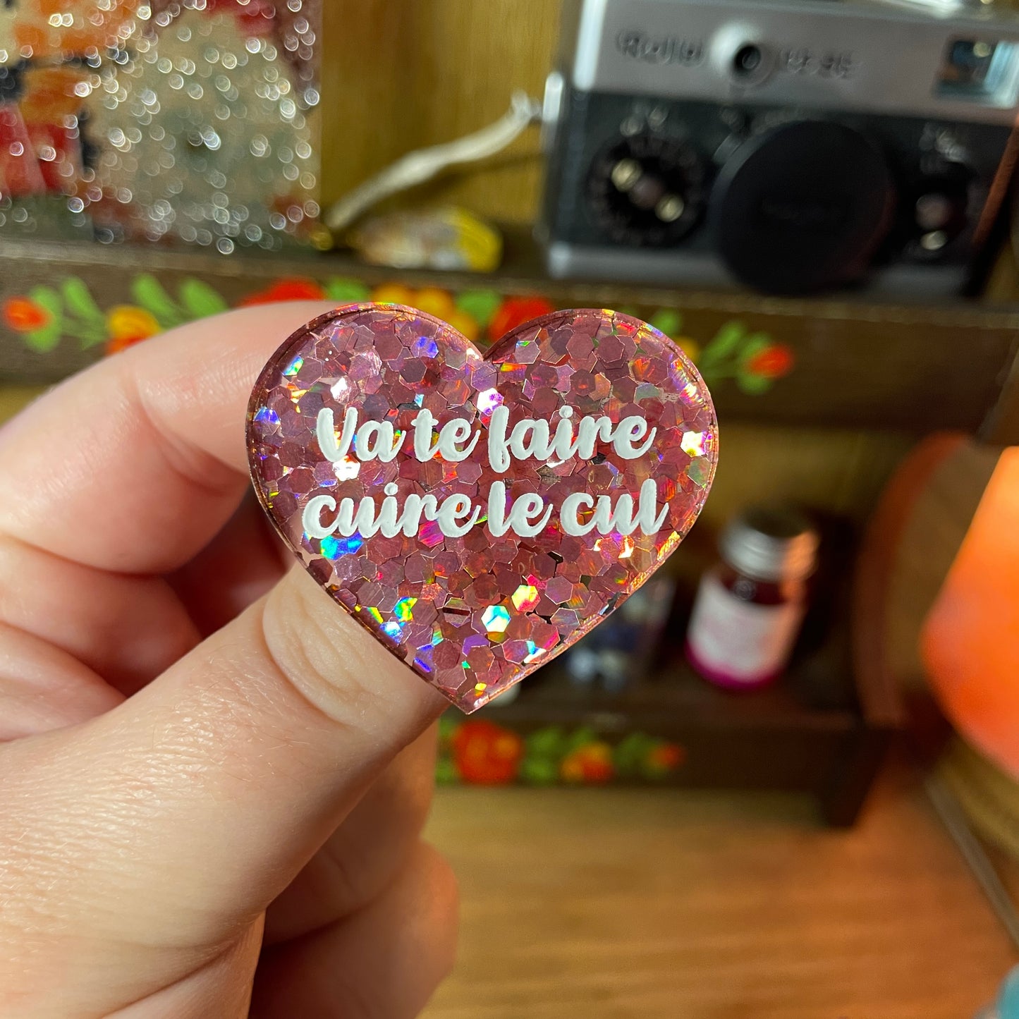 Broche "Va te faire cuire le cul" en acrylique semi transparente avec des confettis corail