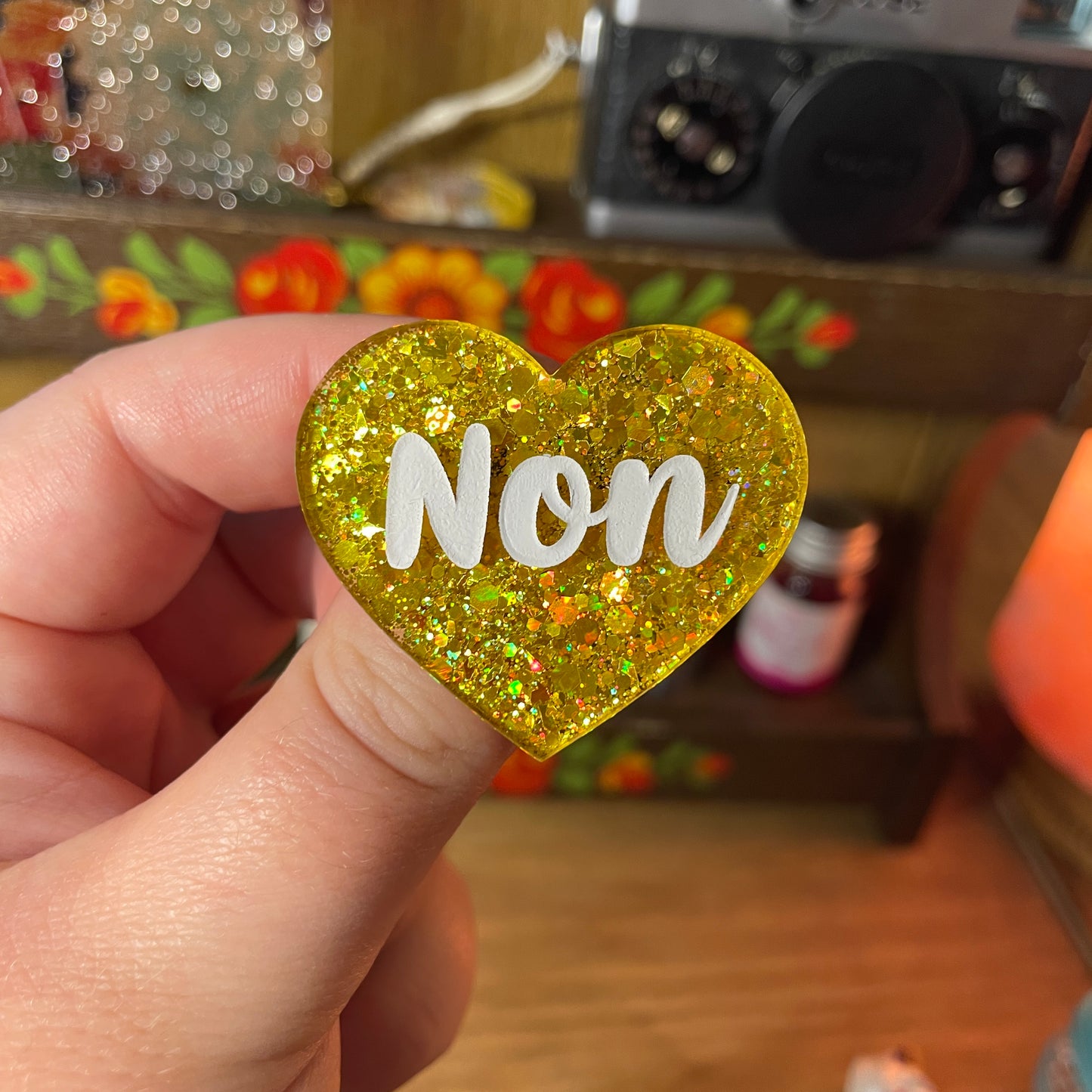Broche "Non" en acrylique semi transparente à paillettes jaunes