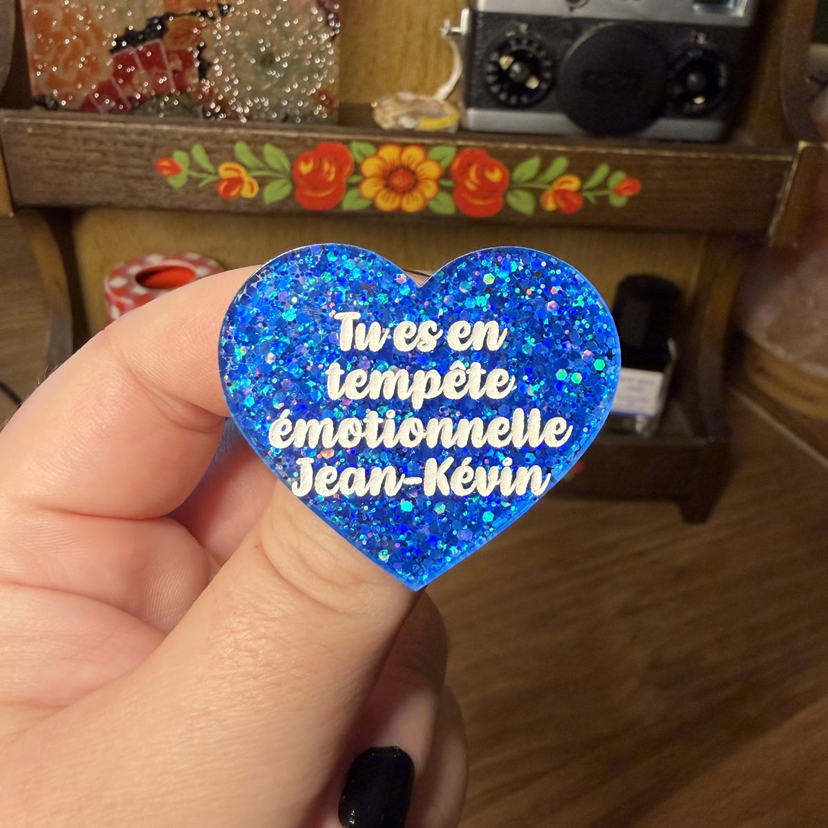Broche "Tu es en tempête émotionnelle Jean-Kévin" en acrylique semi transparente avec des paillettes bleues