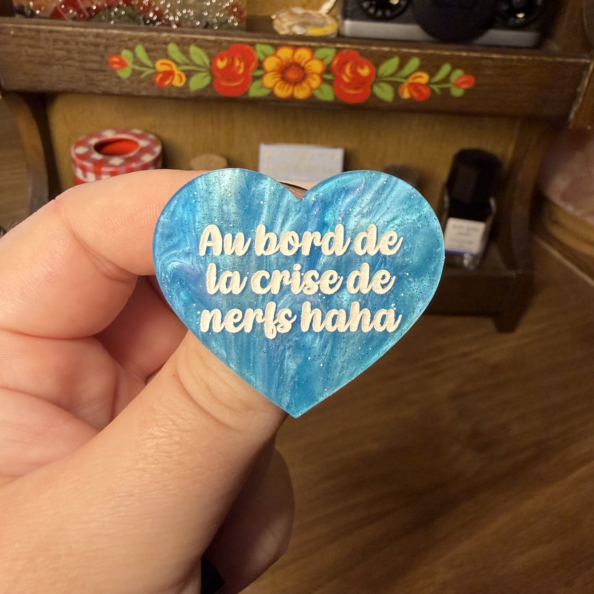 Broche "Au bord de la crise de nerfs haha" en acrylique marbrée bleue à paillettes