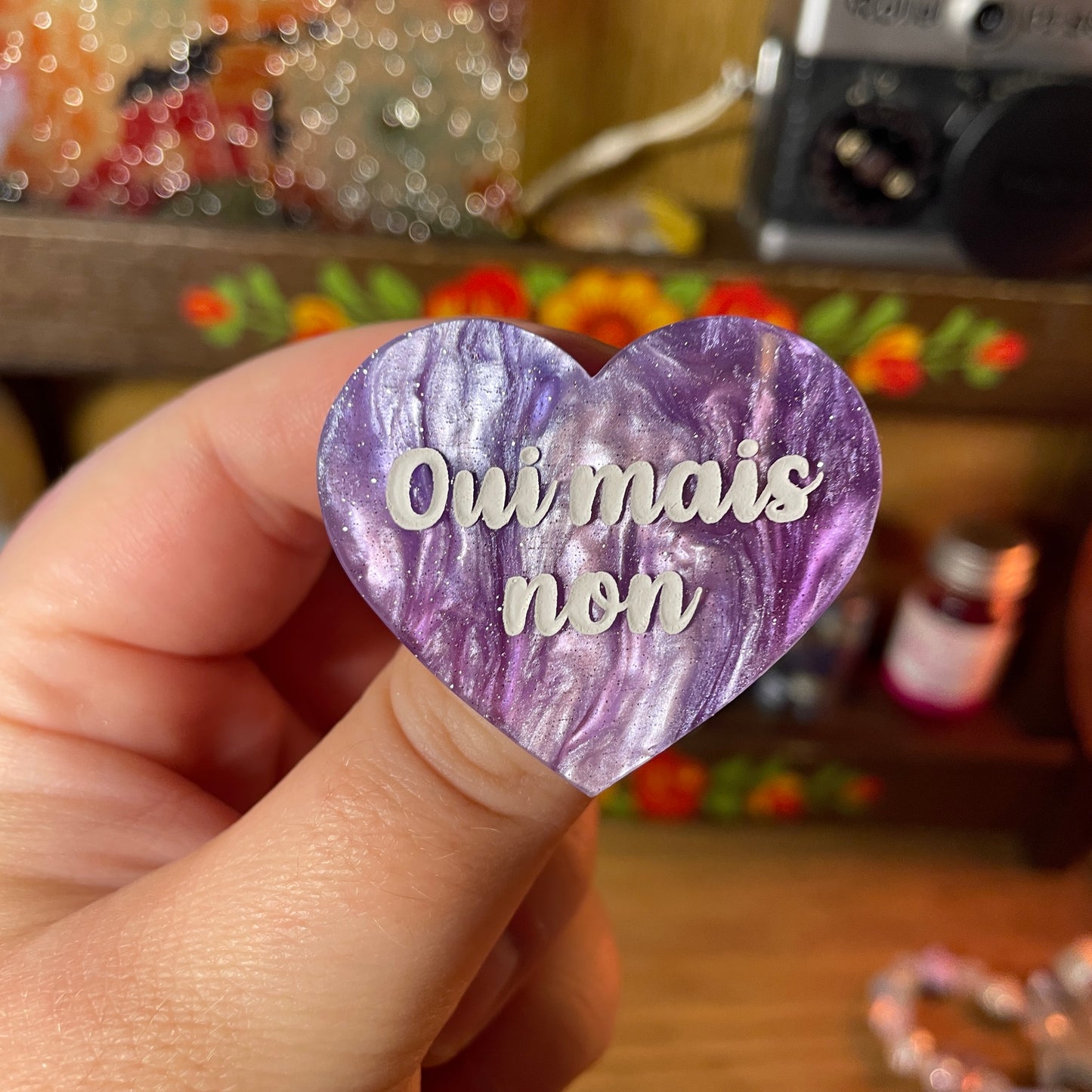 Broche "Oui mais non" en acrylique marbrée bleue, blanche et violette à paillettes