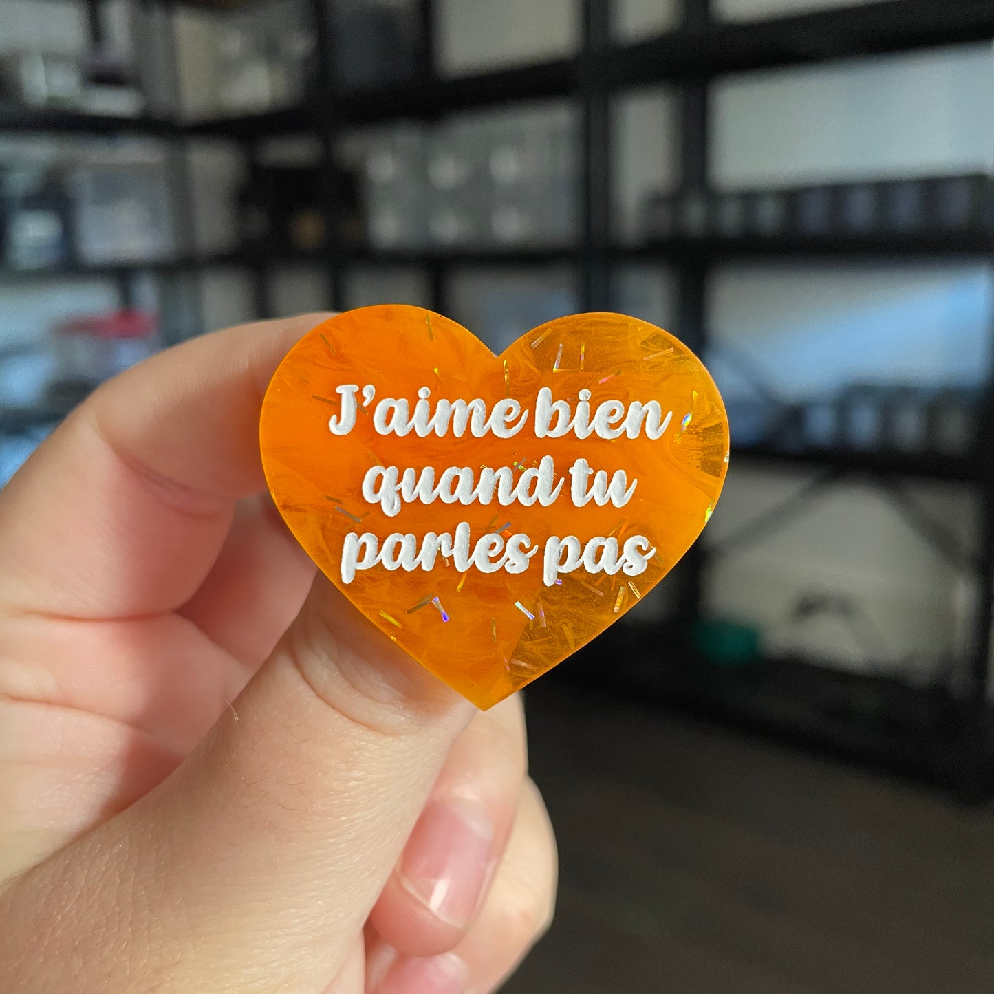 Broche "J'aime bien quand tu parles pas" en acrylique japonaise semi transparente orange avec des confettis