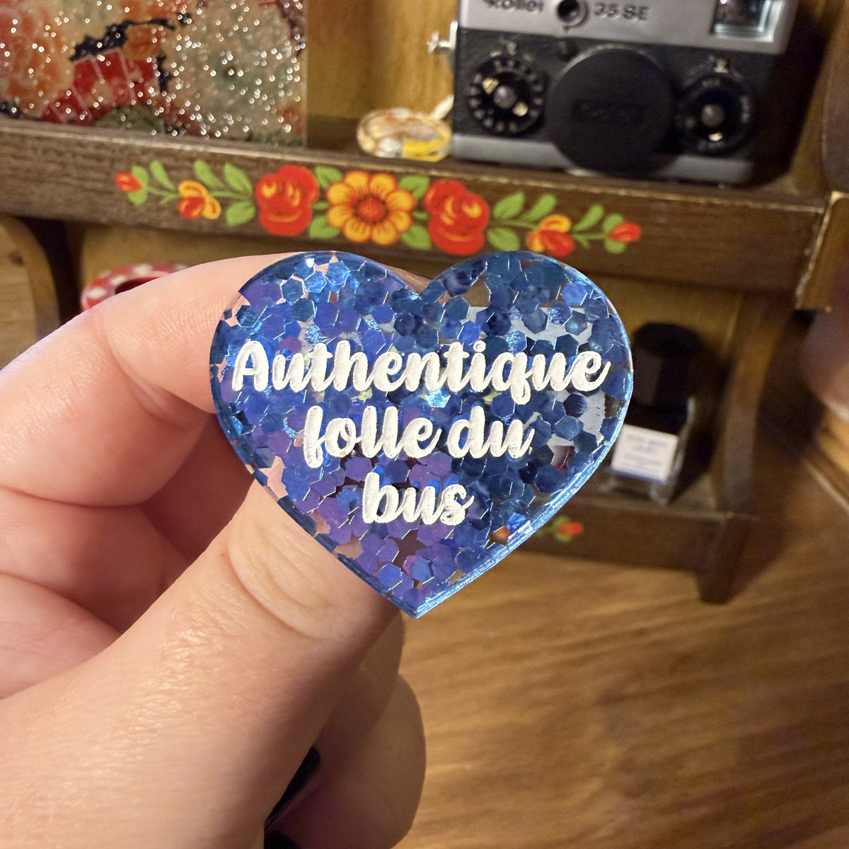 Broche "Authentique folle du bus" en acrylique semi transparente avec des confettis bleus