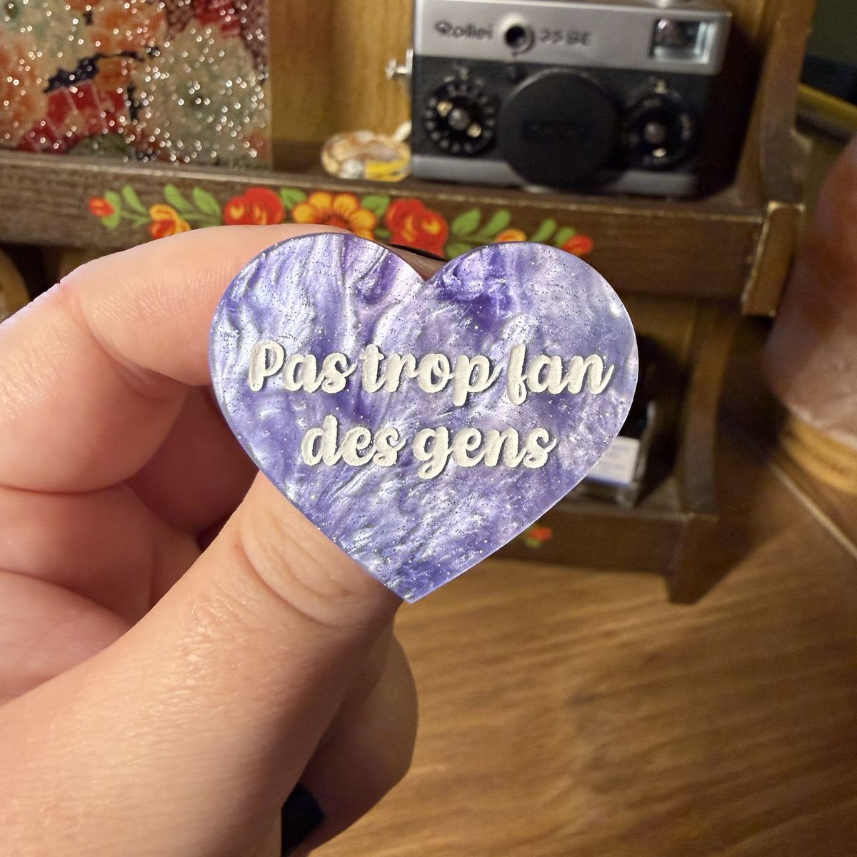 Broche "Pas trop fan des gens" en acrylique marbrée violette, rose et blanche à paillettes