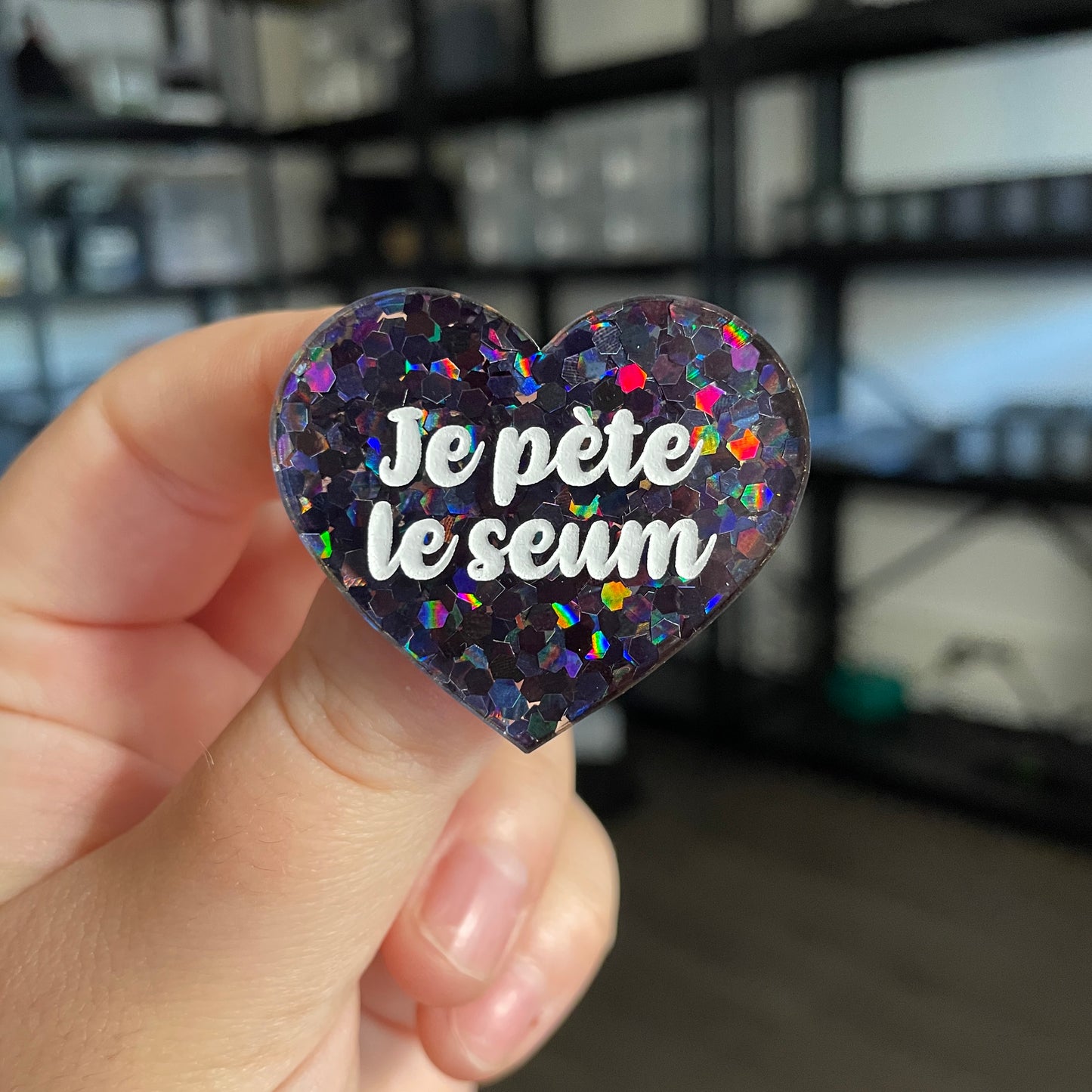 Broche "Je pète le seum" en acrylique semi transparente avec des confettis noirs