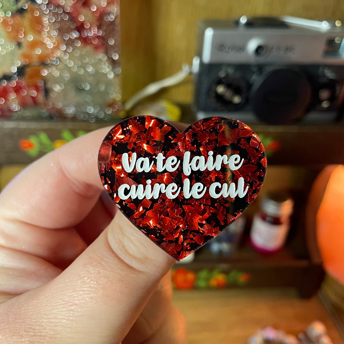 Broche "Va te faire cuire le cul" en acrylique noire avec des éclats de confettis rouges