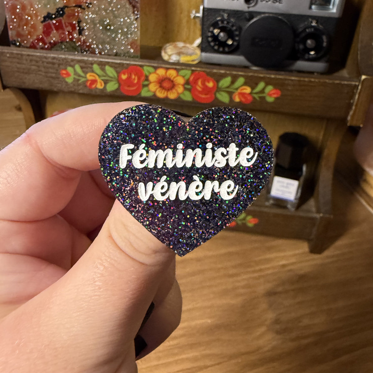 Broche "Féministe vénère" en acrylique à paillettes noires holographiques