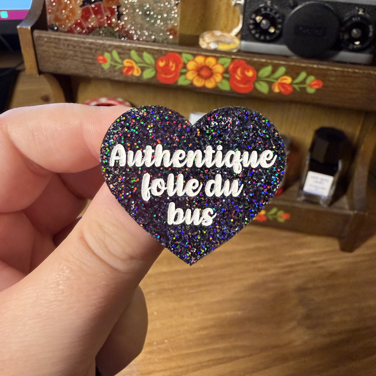 Broche "Authentique folle du bus" en acrylique à paillettes noires holographiques
