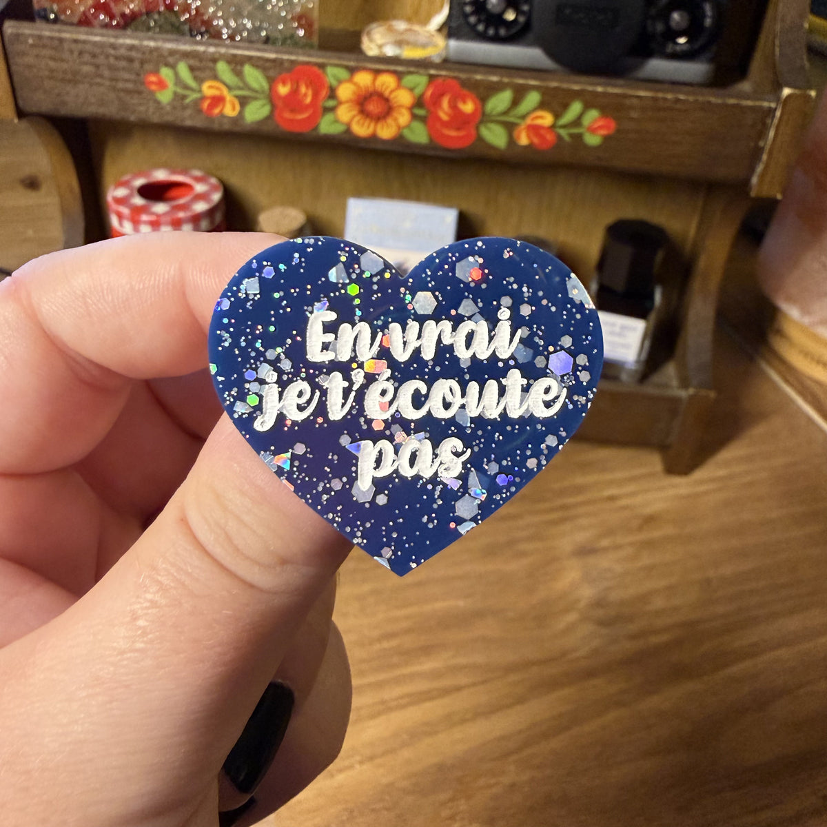 Broche "En vrai je t'écoute pas" en acrylique bleue avec des confettis argentés