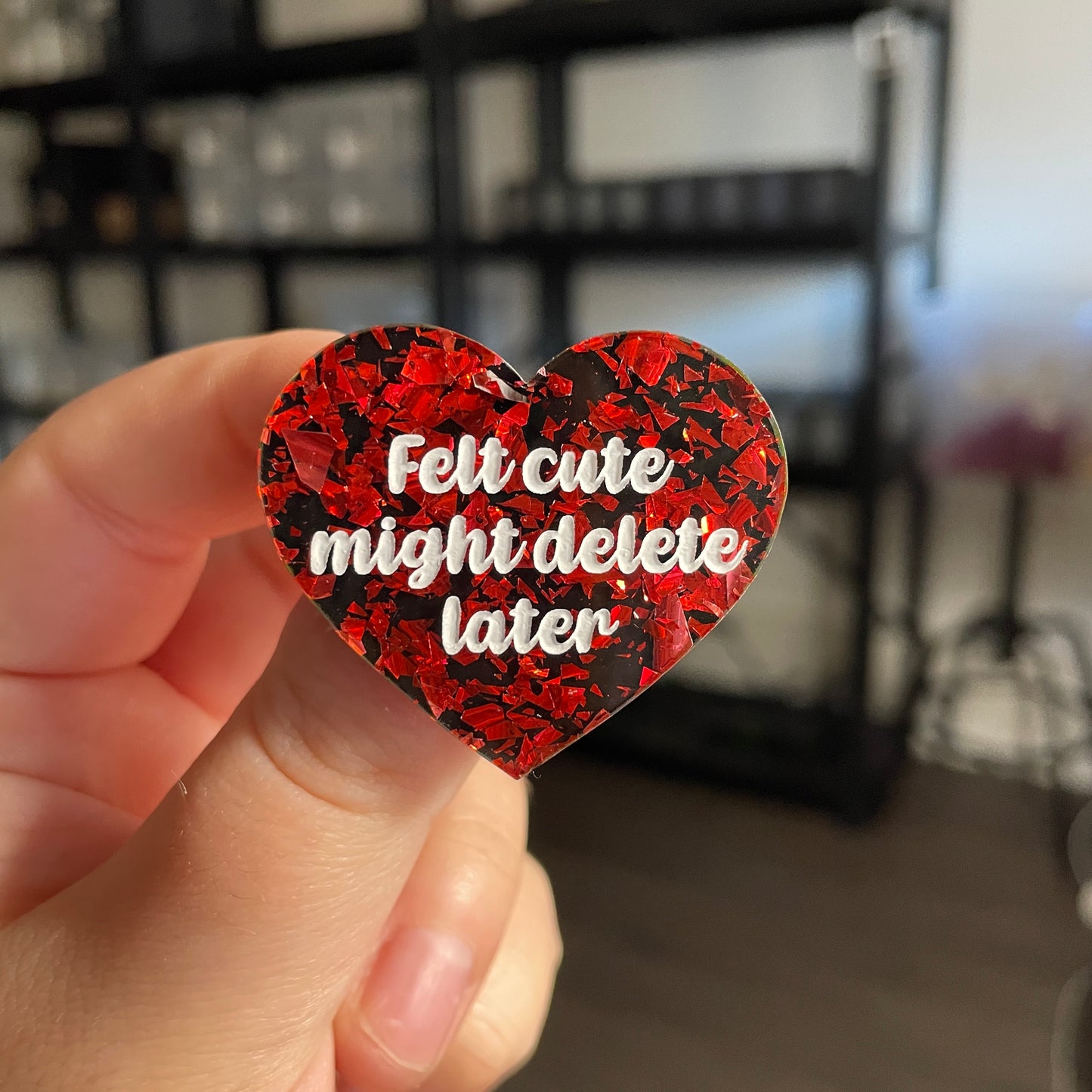 Broche "Felt cute might delete later" en acrylique noire avec des éclats de confettis rouges