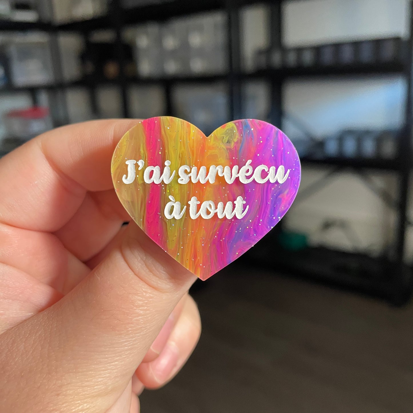 Broche "J'ai survécu à tout" en acrylique semi transparente marbrée multicolore