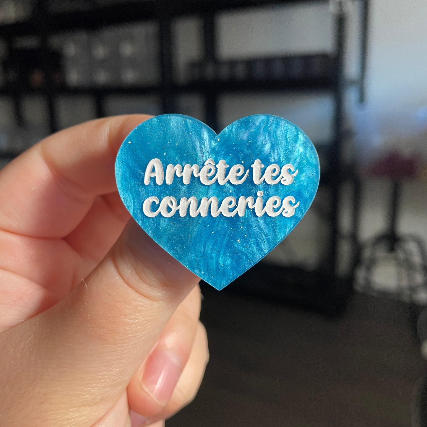 Broche "Arrête tes conneries" en acrylique marbrée bleue à paillettes