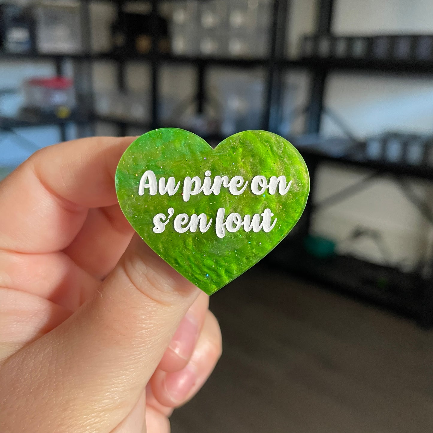 Broche "Au pire on s'en fout" en acrylique marbrée verte à paillettes
