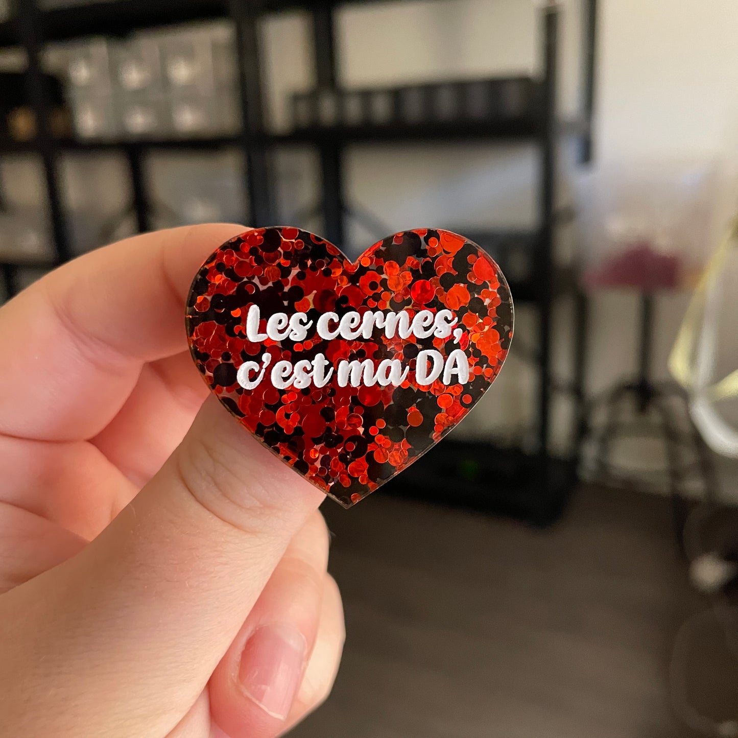 Broche "Les cernes c'est ma DA" en acrylique semi transparente avec des pois rouges et noirs