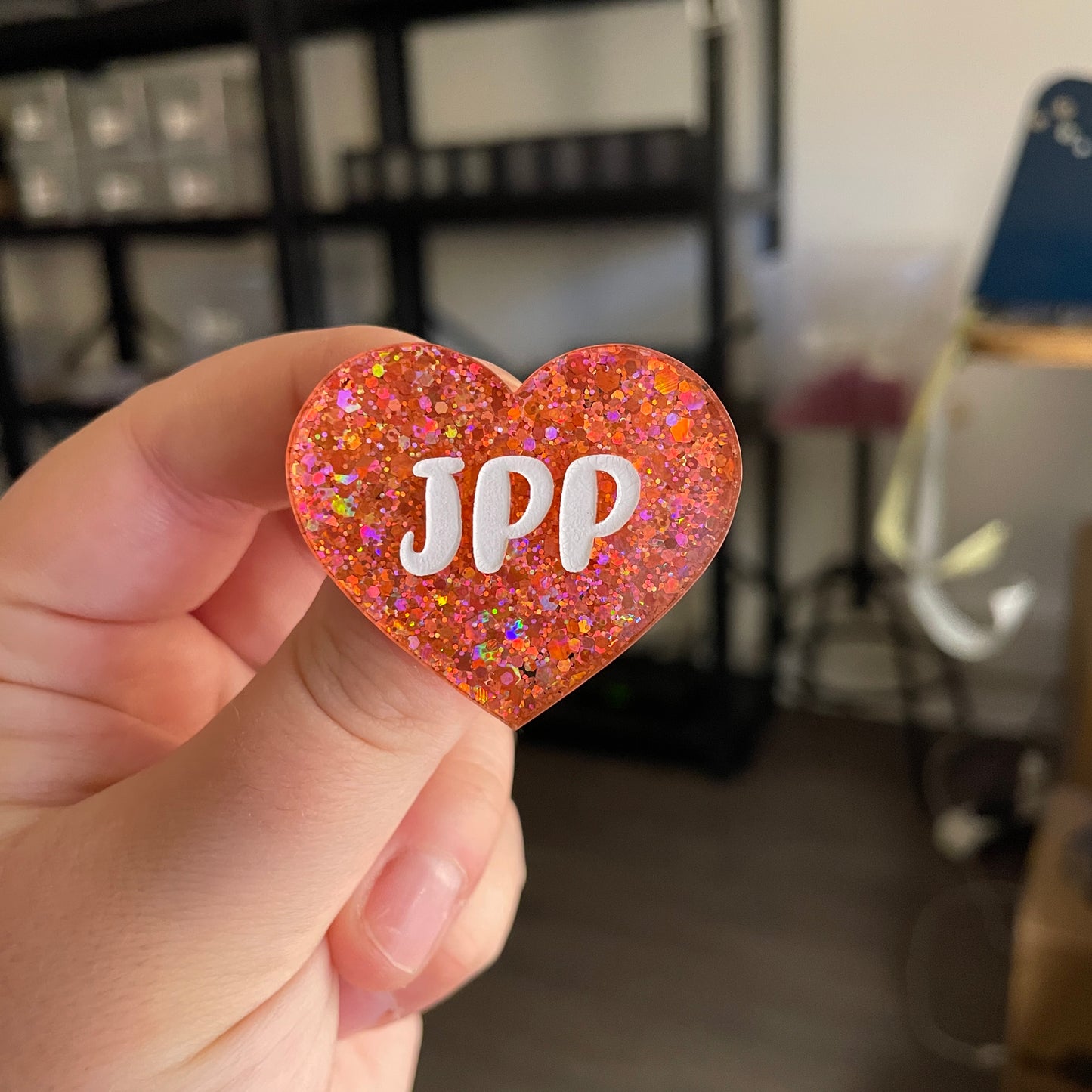 Broche "JPP" en acrylique transparente avec des paillettes corail