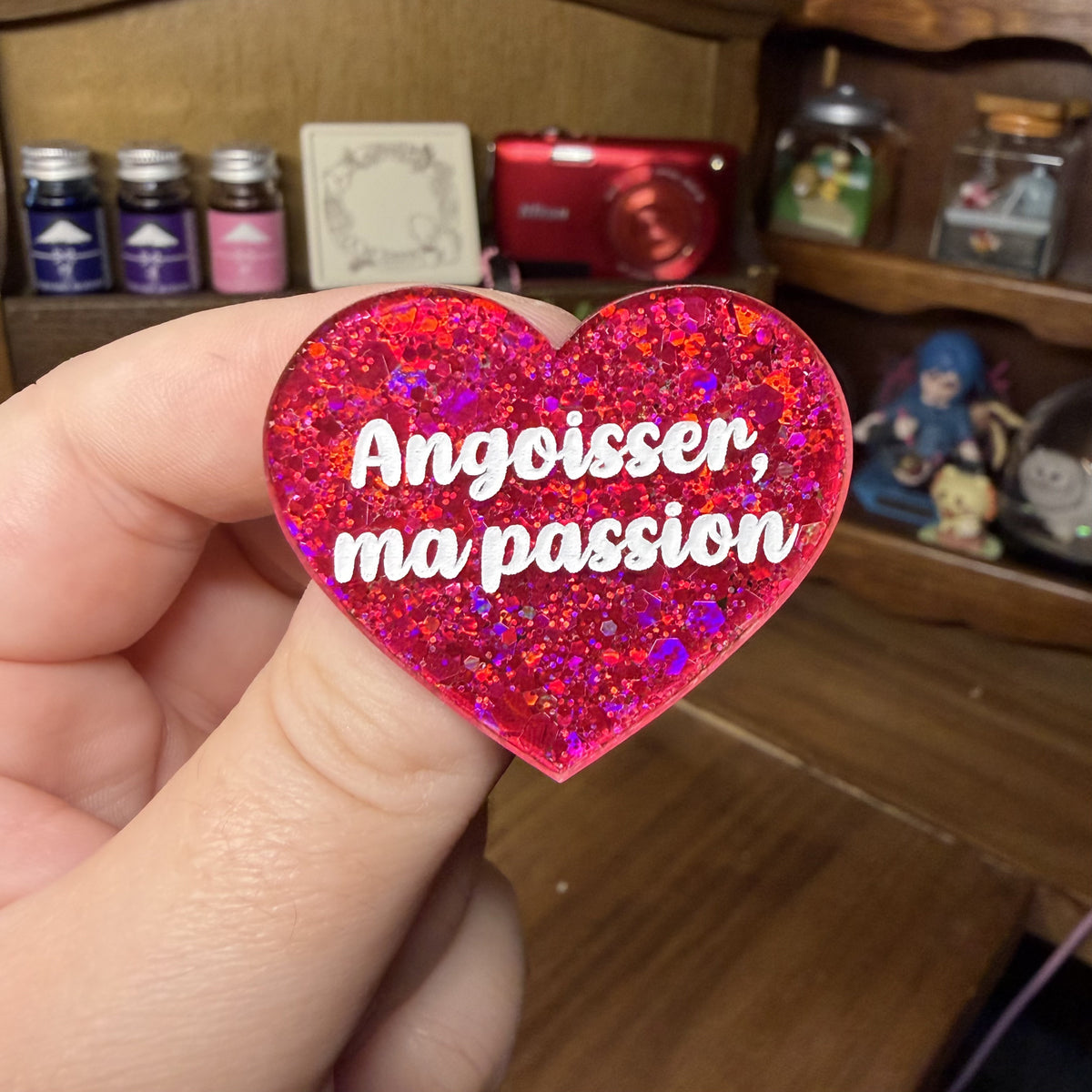 Broche "Angoisser, ma passion" en acrylique à paillettes rouges