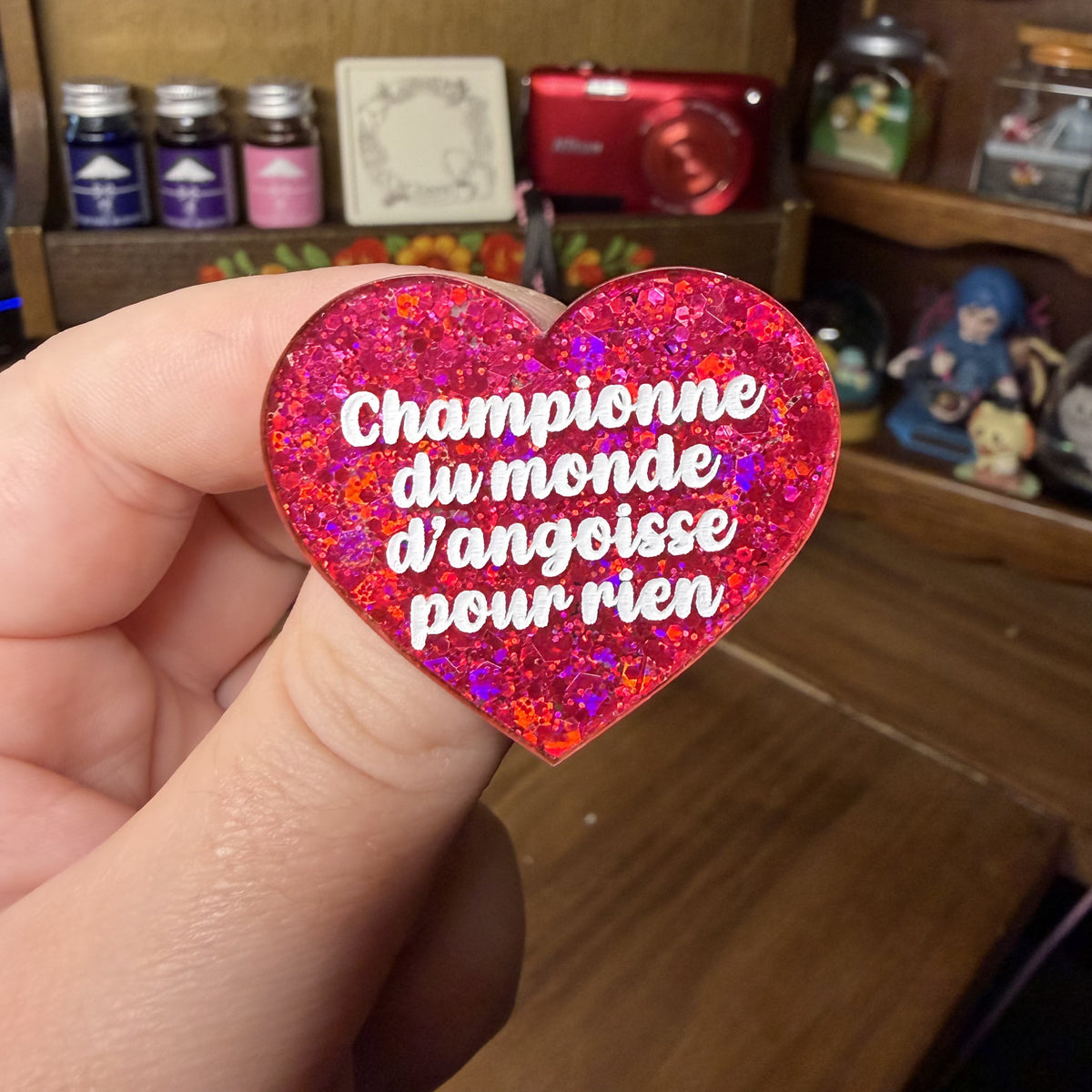 Broche "Championne du monde d'angoisse pour rien" en acrylique à paillettes rouges