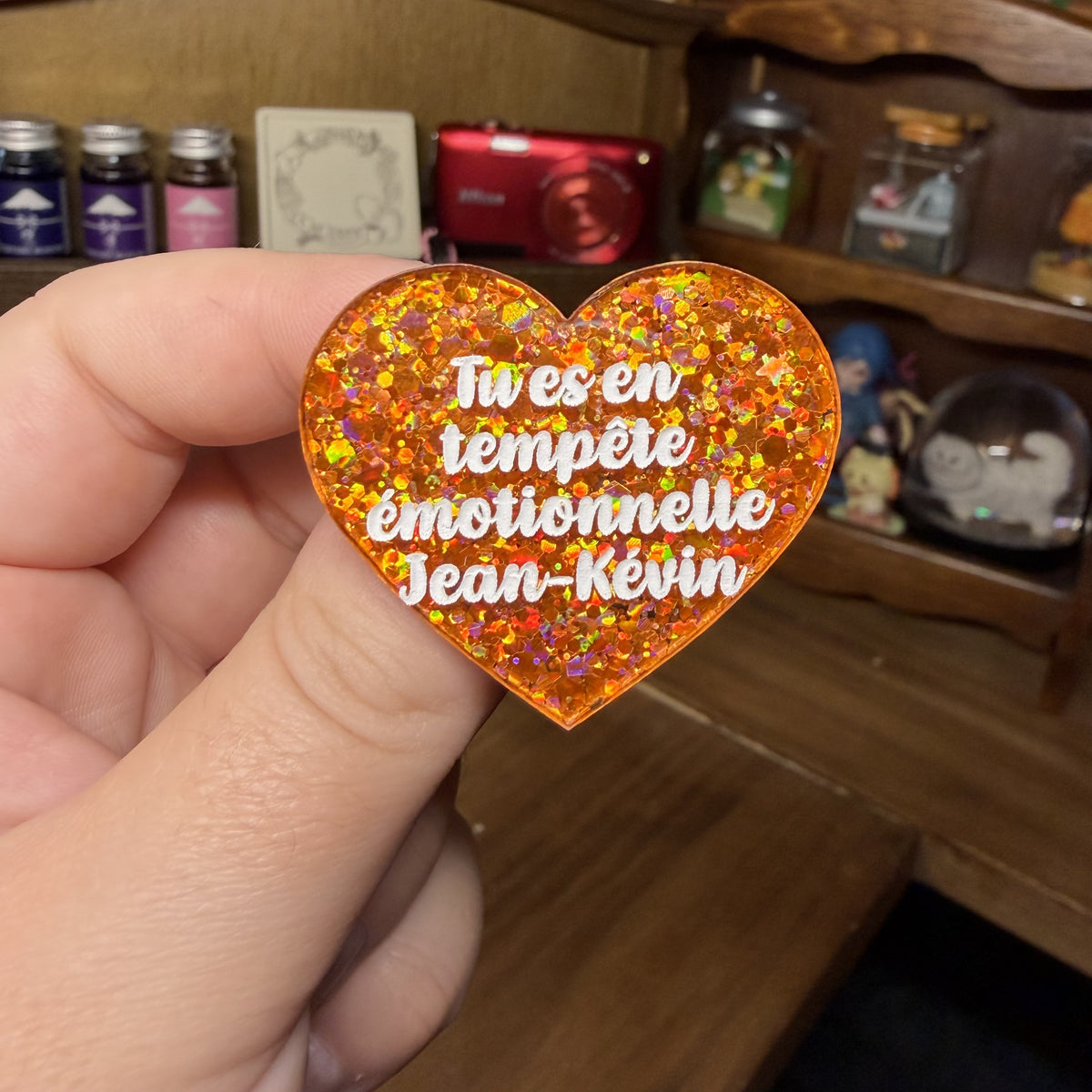 Broche "Tu es en tempête émotionnelle Jean-Kévin" en acrylique à paillettes oranges