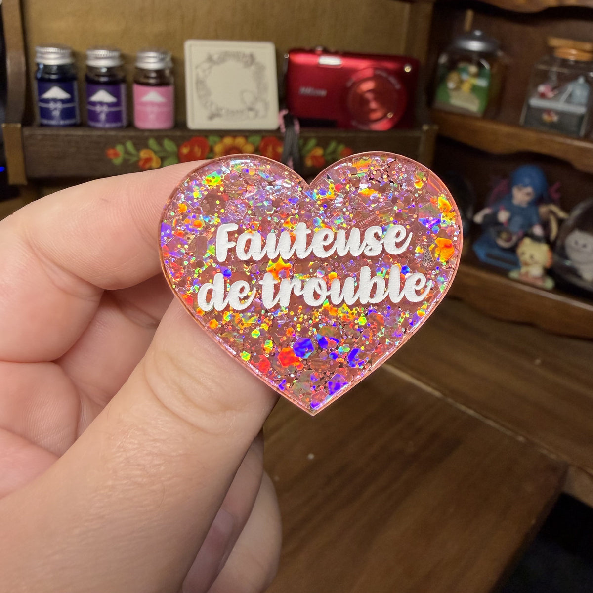 Broche "Fauteuse de trouble" en acrylique semi transparente avec des paillettes corail