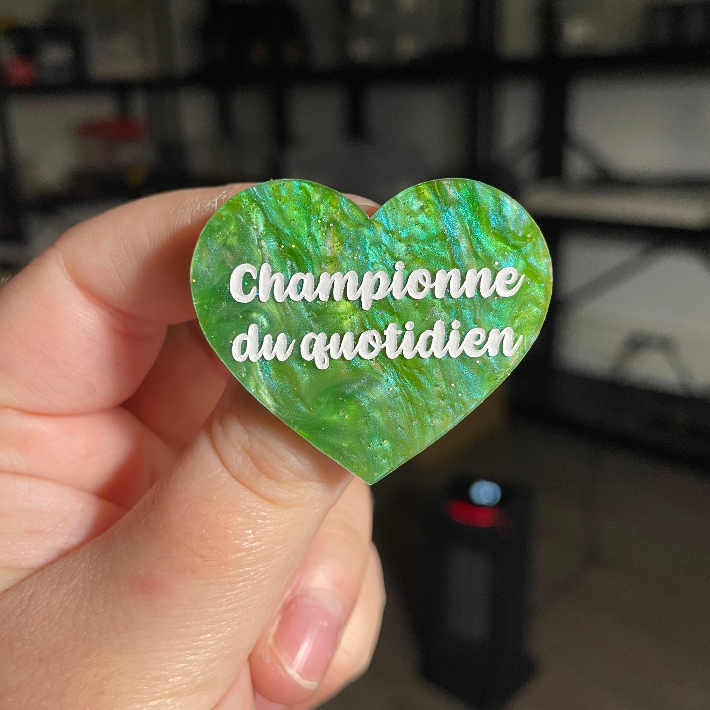 Broche "Championne du quotidien" en acrylique marbrée verte à paillettes