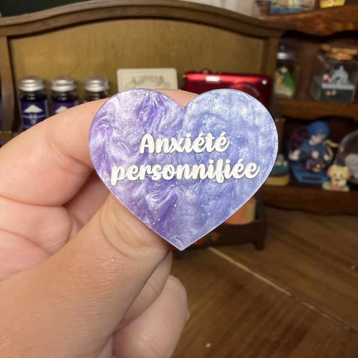 Broche "Anxiété personnifée" en acrylique marbrée violette, rose et blanche à paillettes