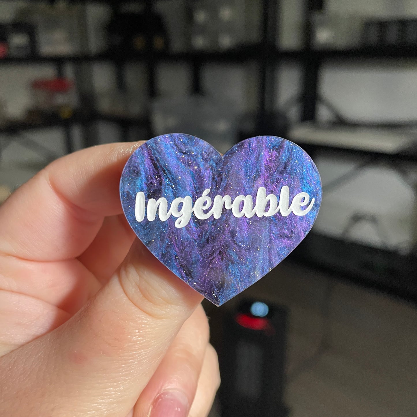 Broche "Ingérable" en acrylique marbrée bleue, noire et violette à paillettes