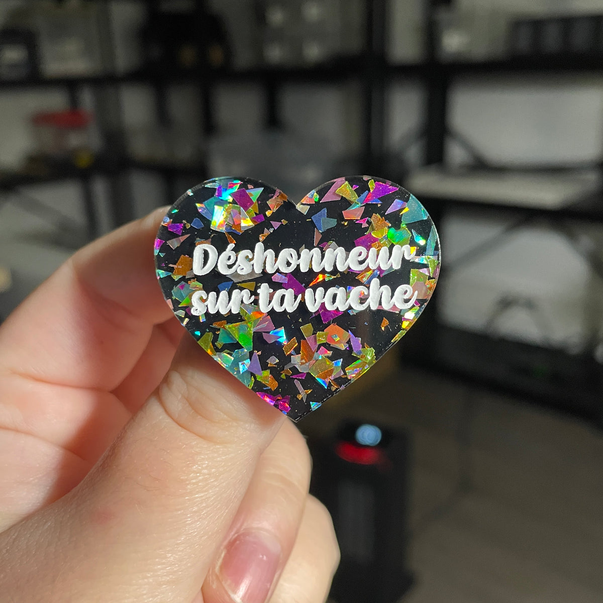 Broche "Déshonneur sur ta vache" en acrylique noire avec des éclats de confettis multicolores