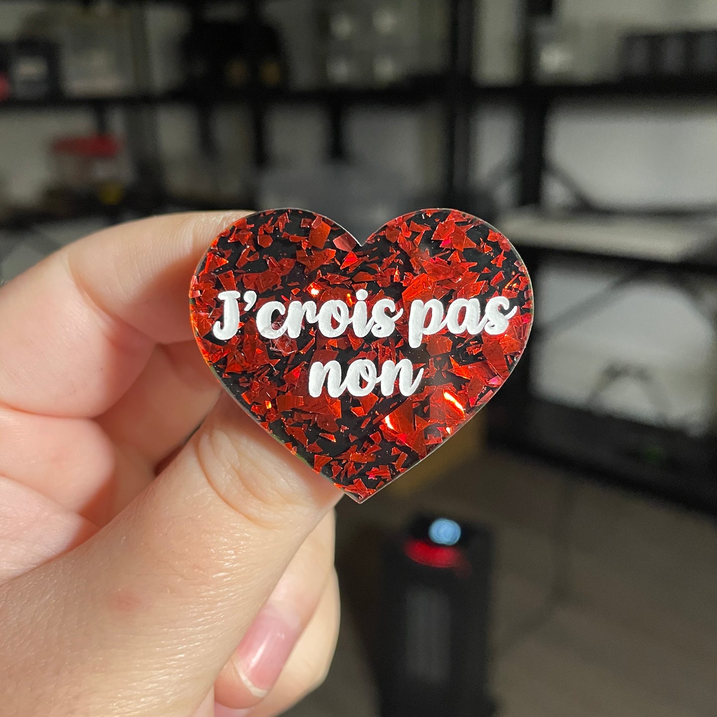 Broche "J'crois pas non" en acrylique noire avec des éclats de confettis rouges