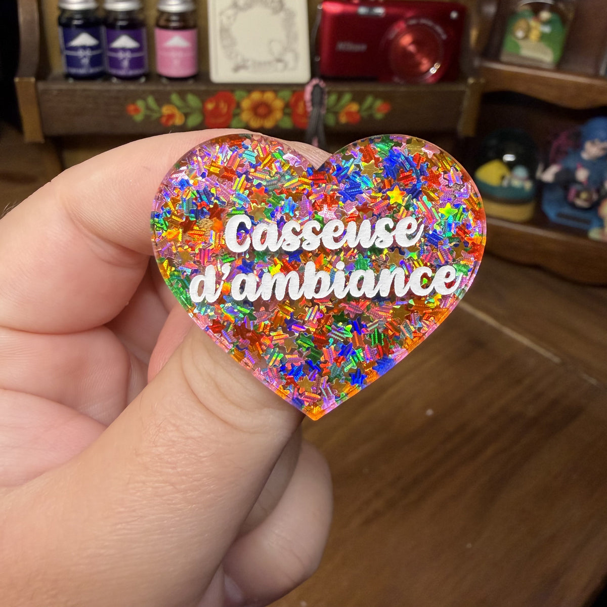 Broche "Casseuse d'ambiance" en acrylique semi transparente avec des étoiles multicolores
