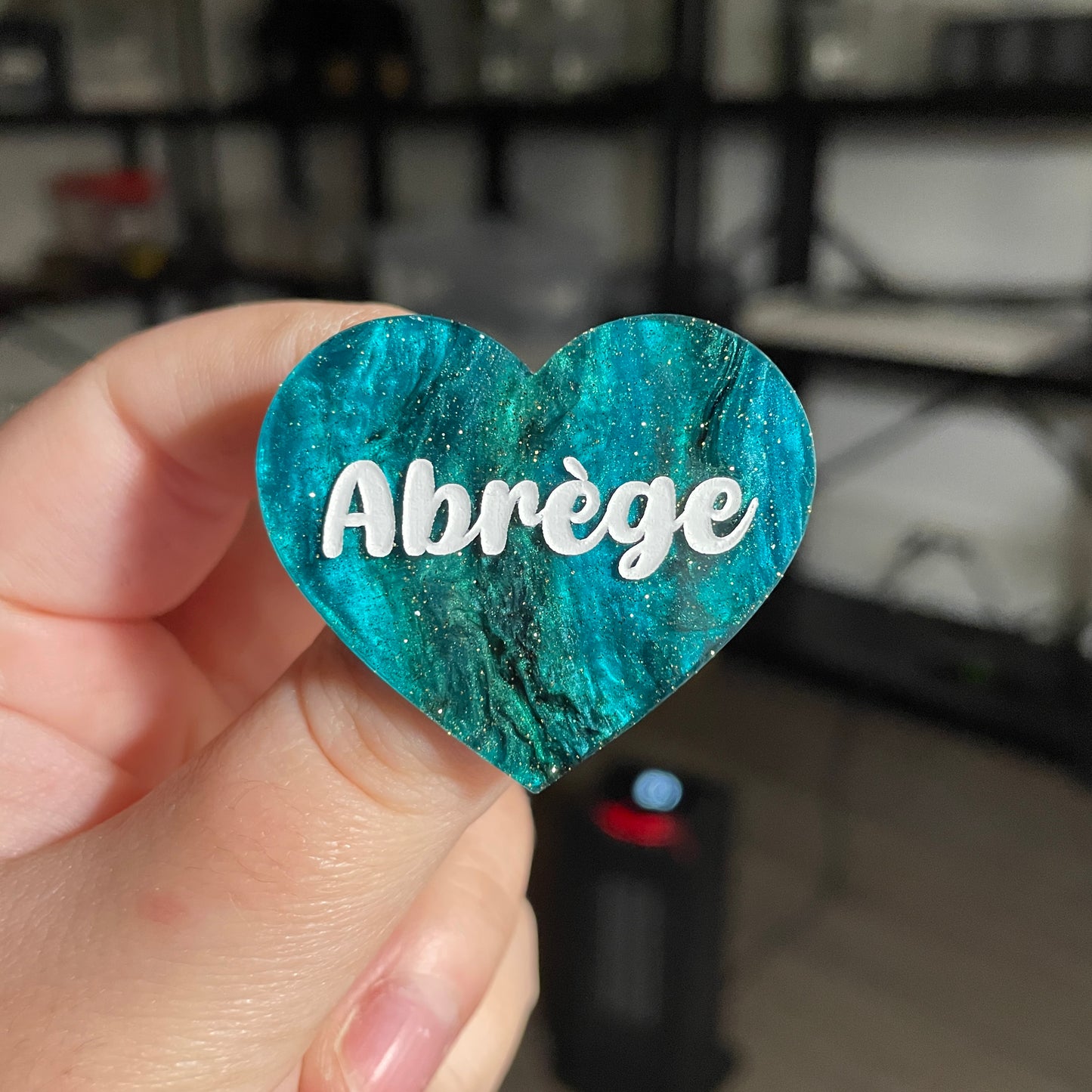 Broche "Abrège" en acrylique marbrée verte et noire à paillettes