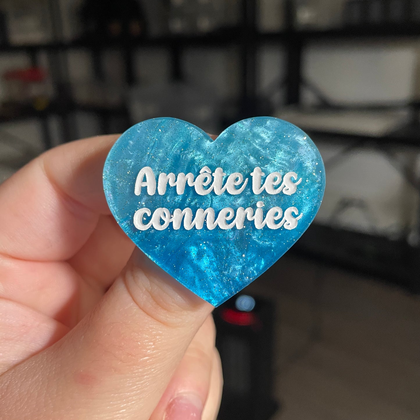 Broche "Arrête tes conneries" en acrylique marbrée bleue à paillettes